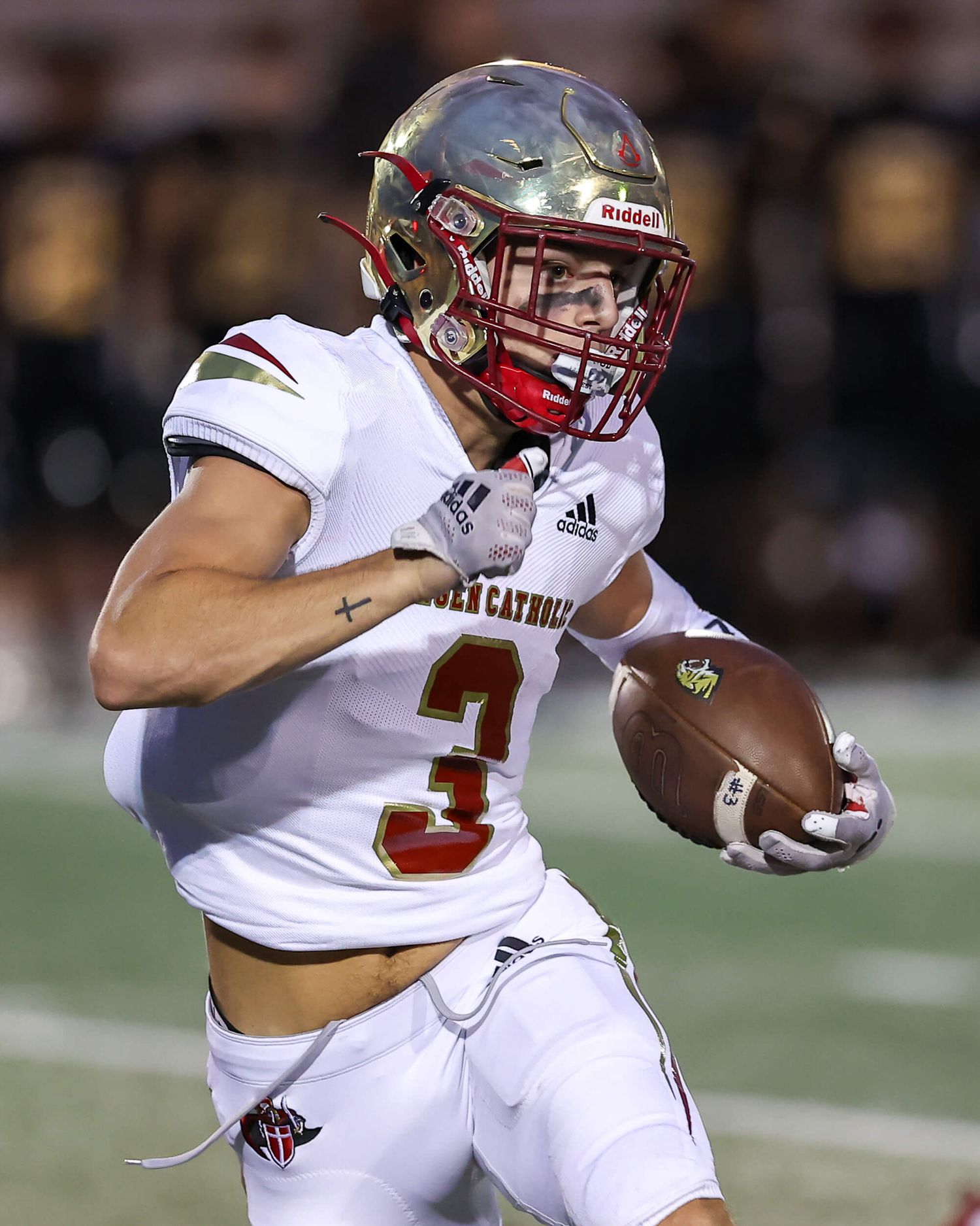 High school football player number 3 in white uniform runs with ball.
