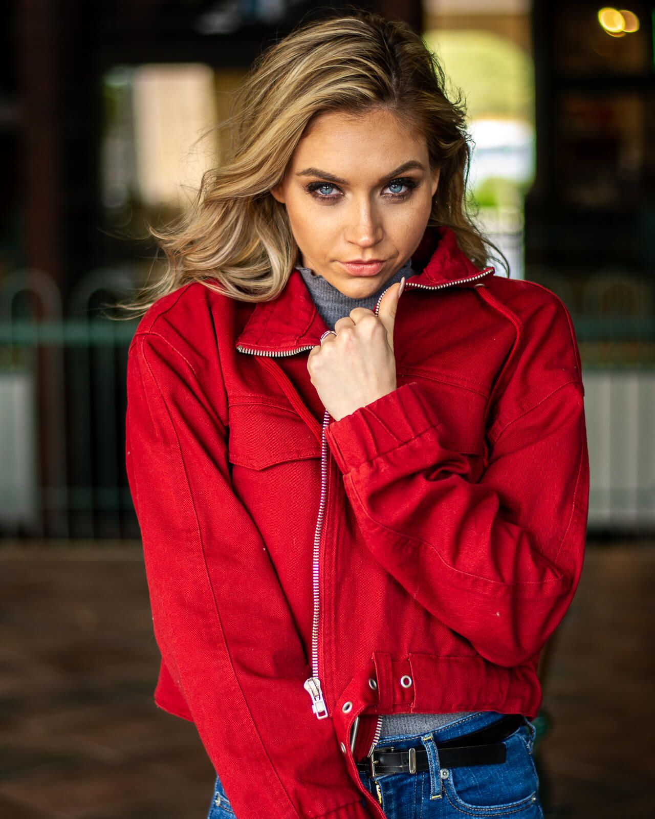 A young blonde blue eyed model in a red jacket striking a pose in Gilbert, Arizona