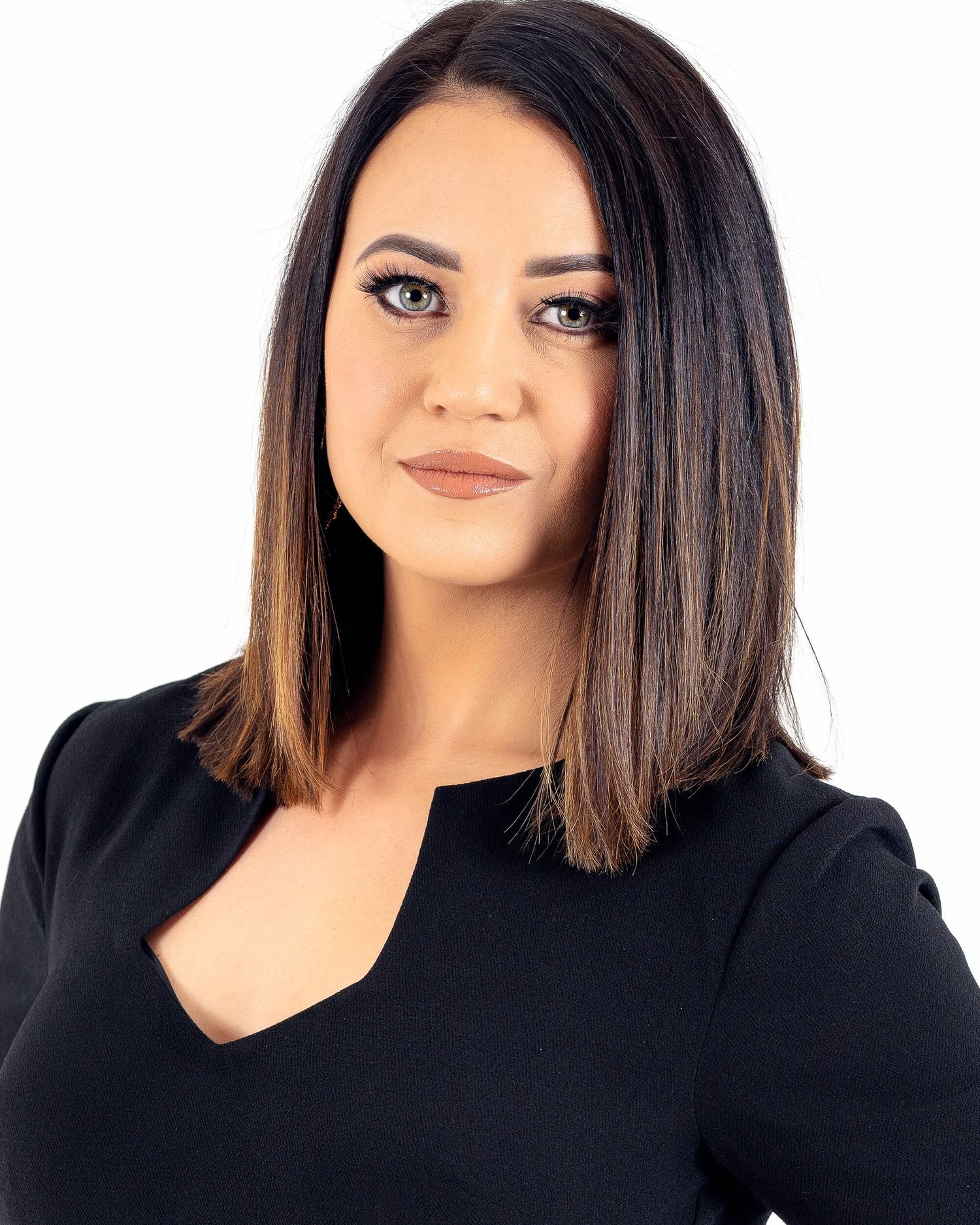 Professional woman with shoulder-length brunette hair wearing a black top against white background.