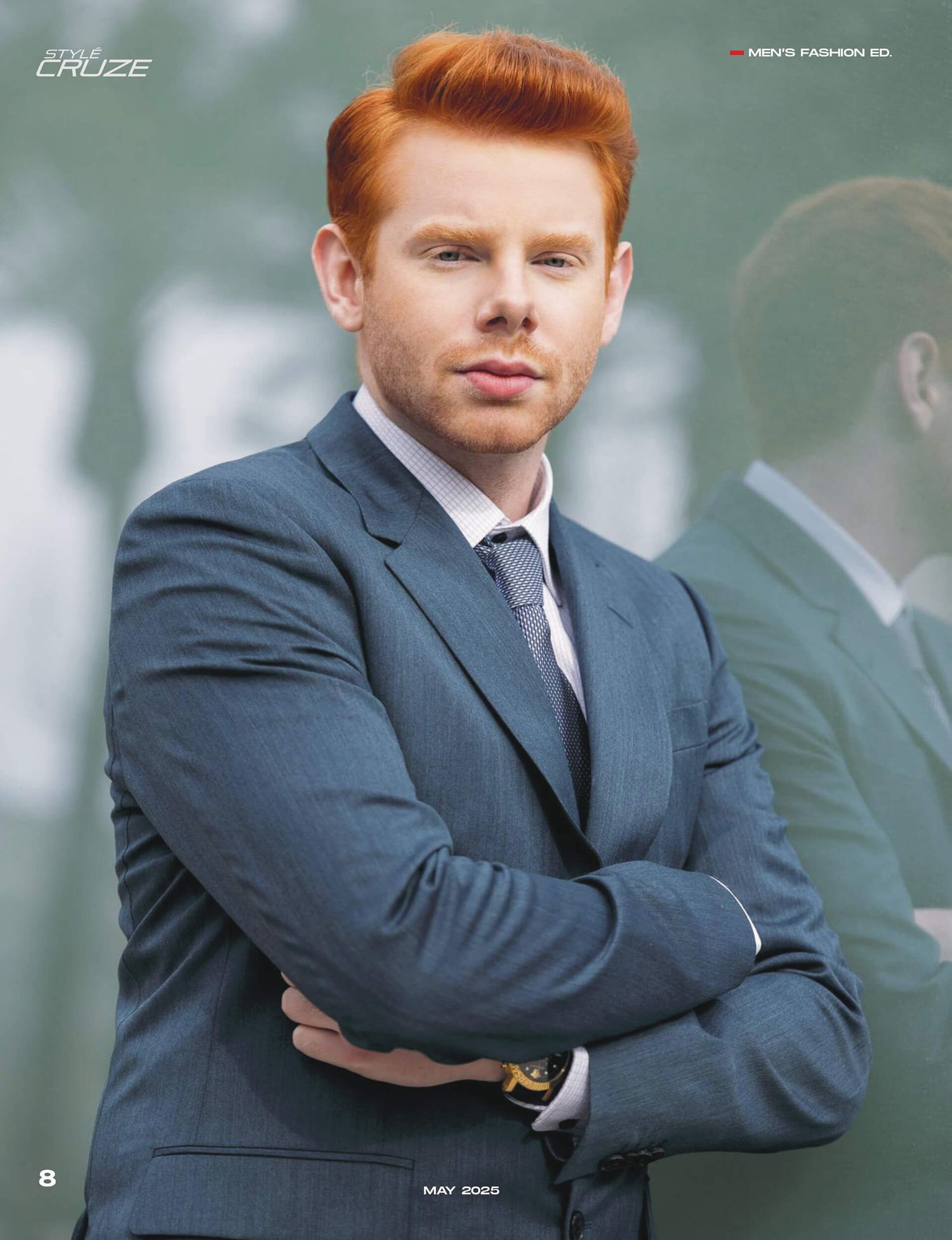 Red-haired man in grey suit with crossed arms poses for Project Cruze mens fashion editorial May 2025.