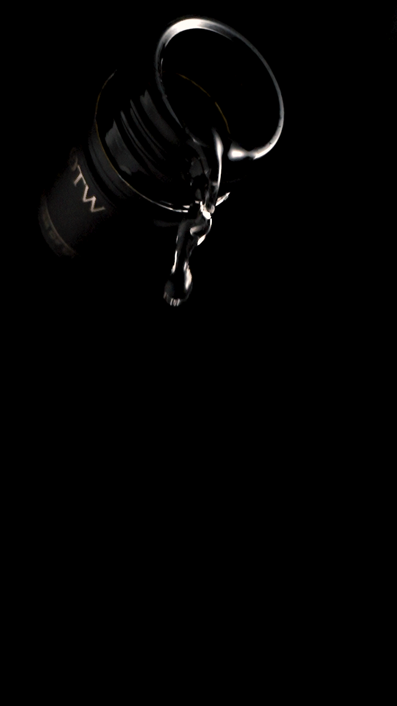 Slow-motion wine pouring captured with dramatic lighting for a cinematic luxury beverage commercial.