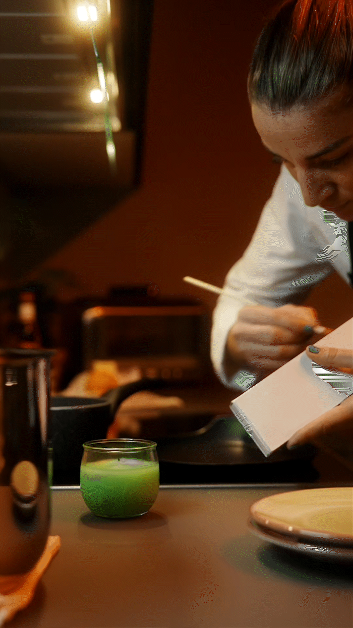 Chef plating a gourmet dish in a cinematic restaurant commercial with warm and elegant lighting.