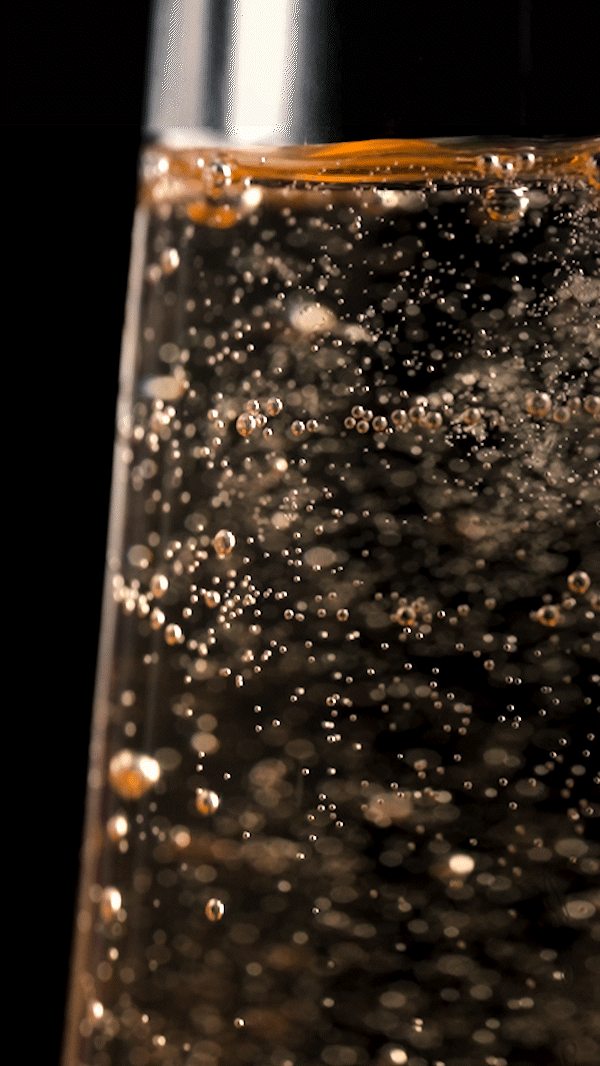 Luxury wine bottle surrounded by sparkling bokeh in a cinematic product film with premium lighting.