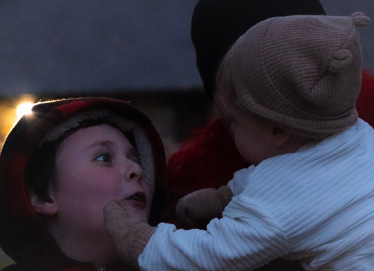 Young child and baby sharing a sweet moment together outdoors in the evening light. Neo Ohio, outdoors, family.