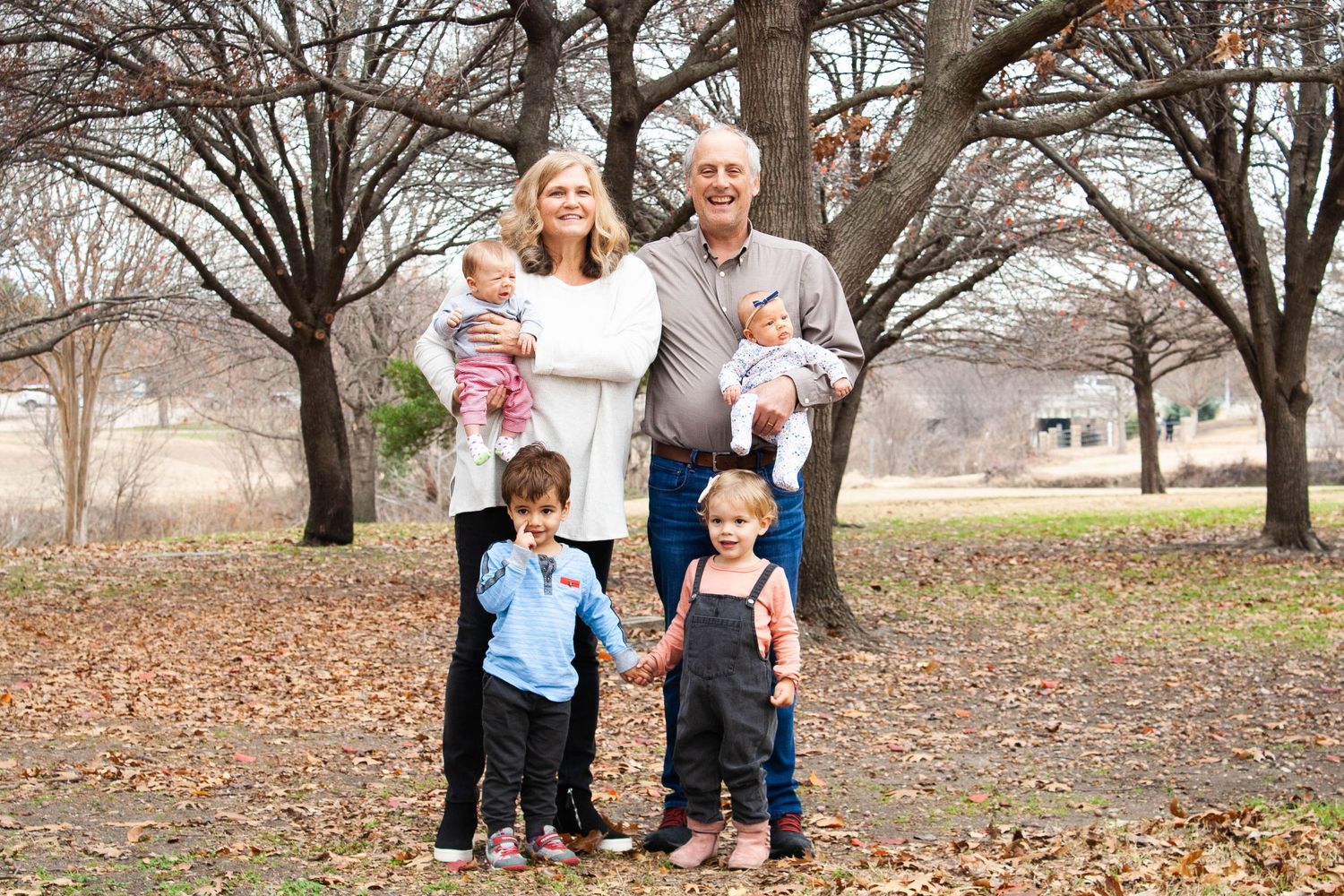 Vibrant autumn family photography featuring grandparents smiling with their grandchildren during an fall photo shoot at Chisholm Trail.