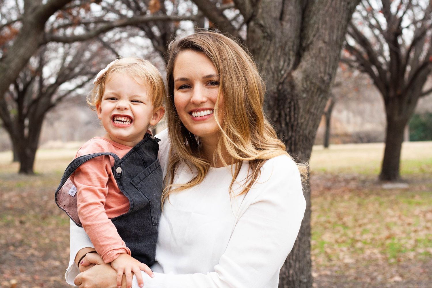 Vibrant outdoor family photography of a happy mother and daughter smiling together during a portrait session at Chisholm Trail Park in Plano