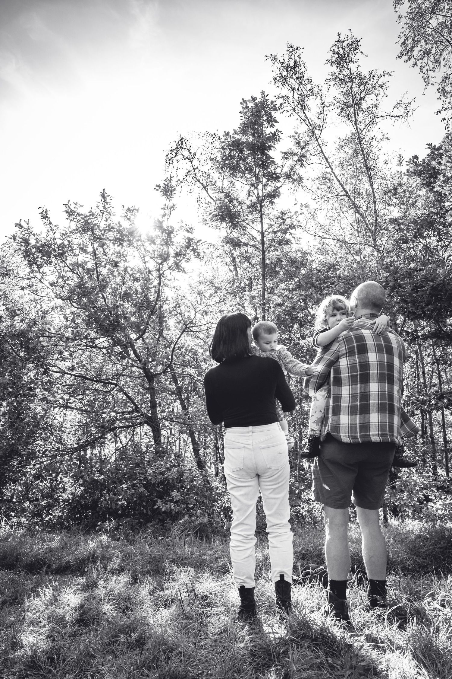 Silhouettes of family members walking together against a bright natural backdrop.