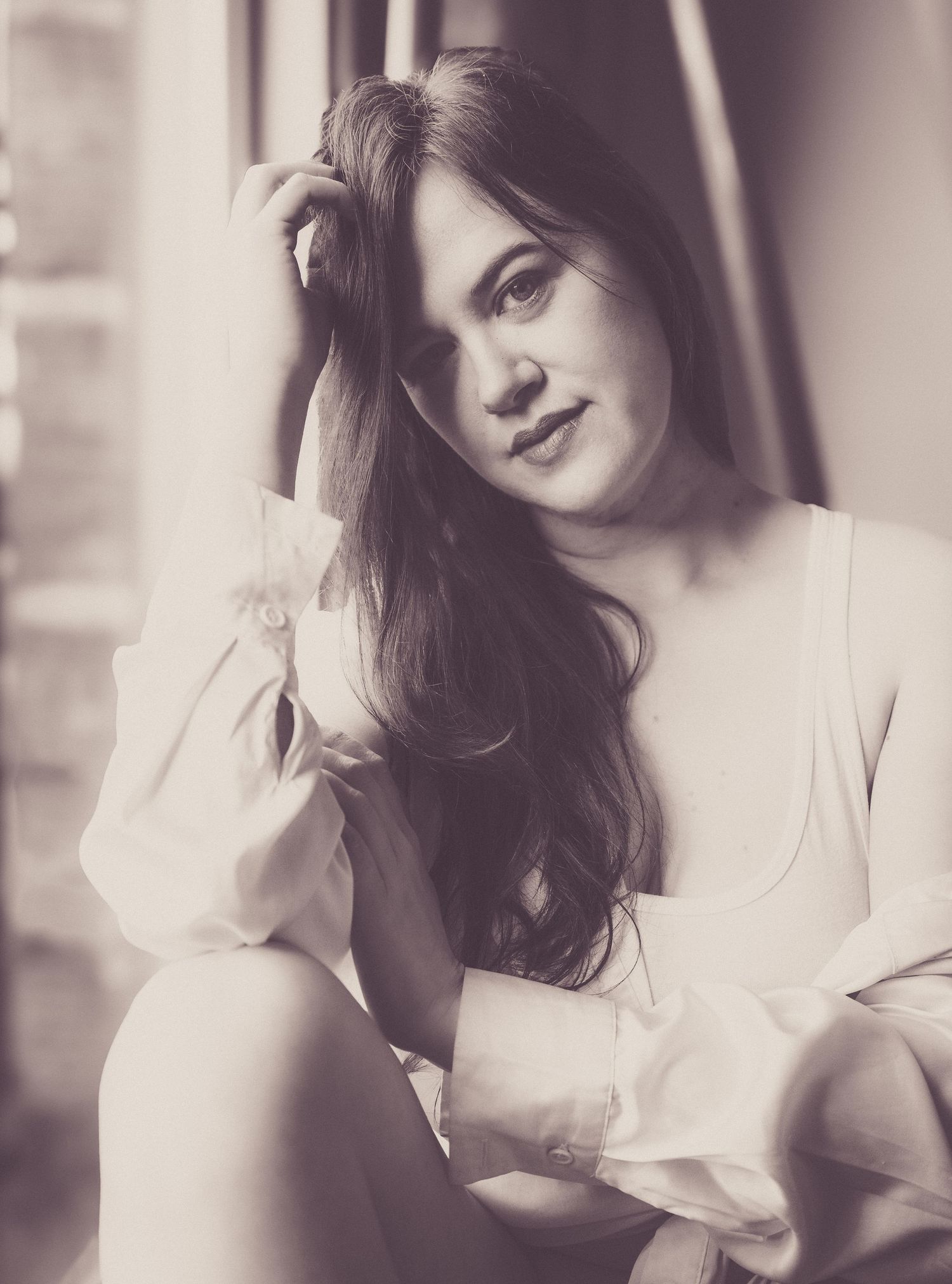 Soft focus vintage-style portrait with delicate white fabric in natural window light.