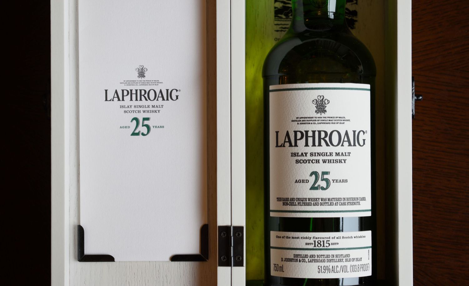 Laphroaig 25 Year Islay Single Malt Scotch Whisky bottle resting in its premium white hinged wooden gift box.