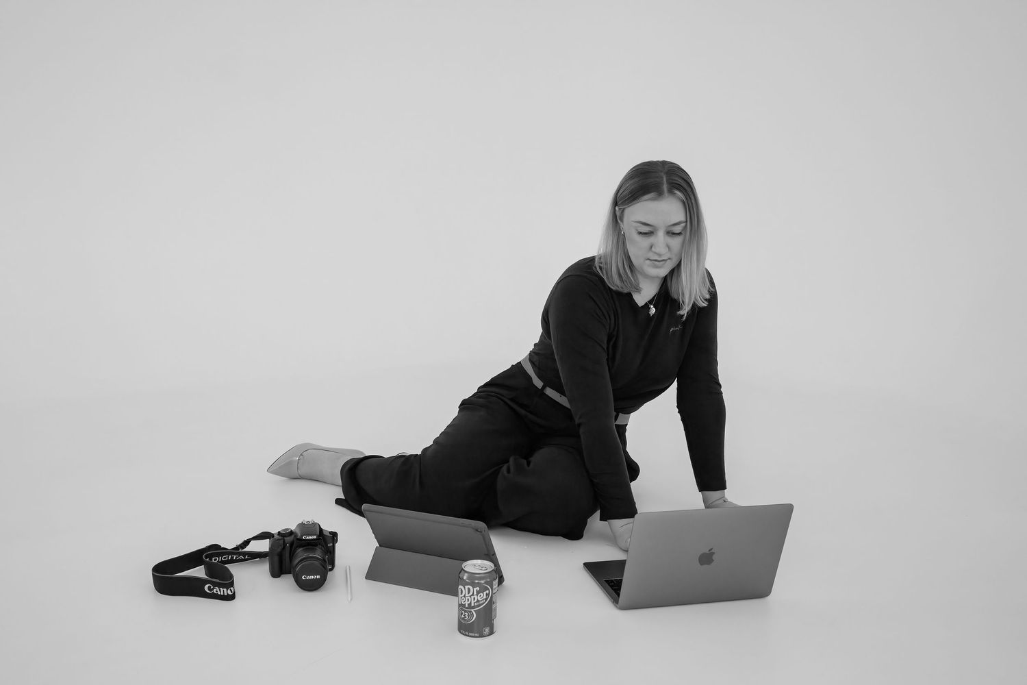 Image of Becka working with computer, camera, ipad, and dr pepper