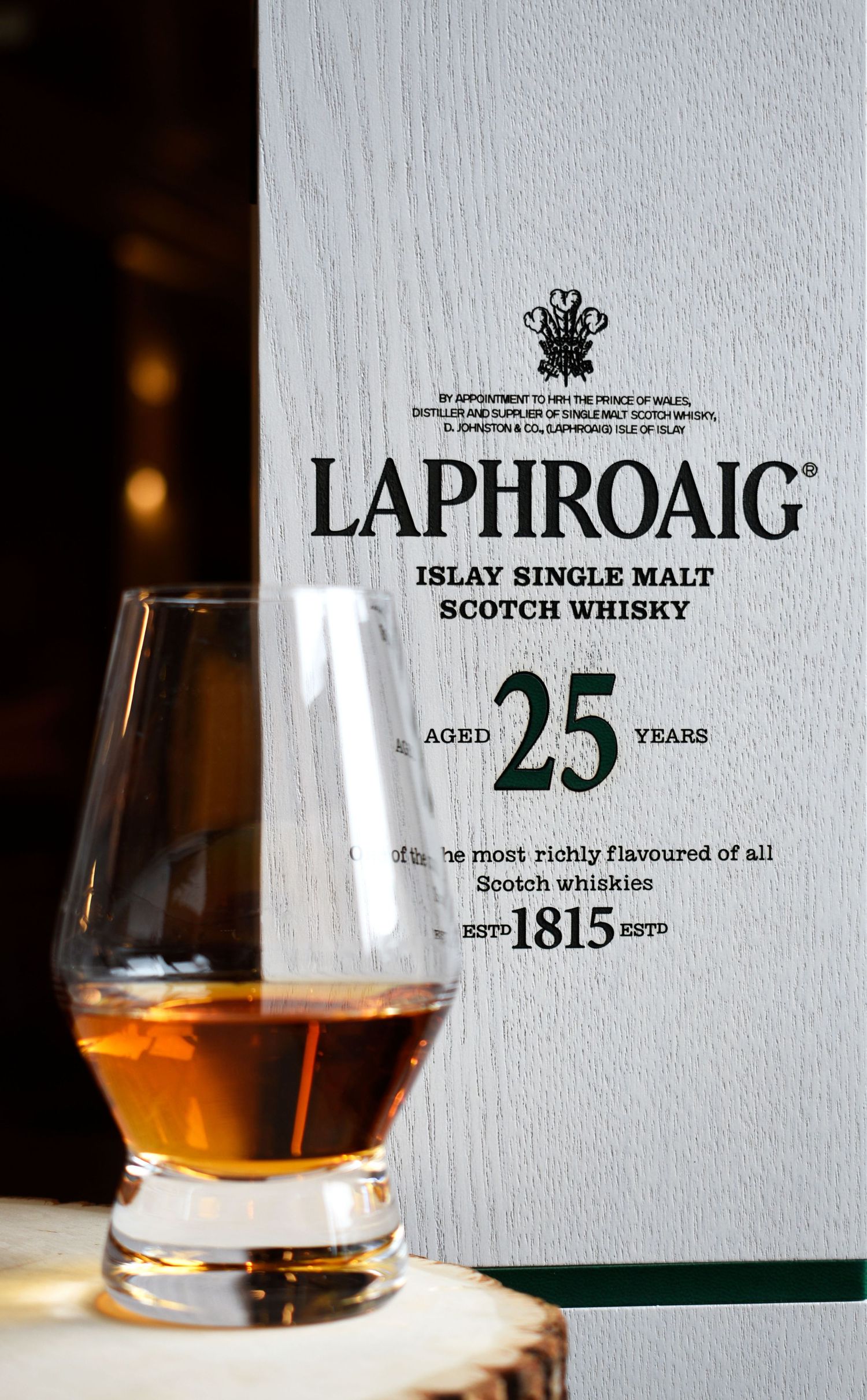 Laphroaig 25 Year Islay Single Malt Scotch Whisky box with a Glencairn glass of whisky, established 1815.