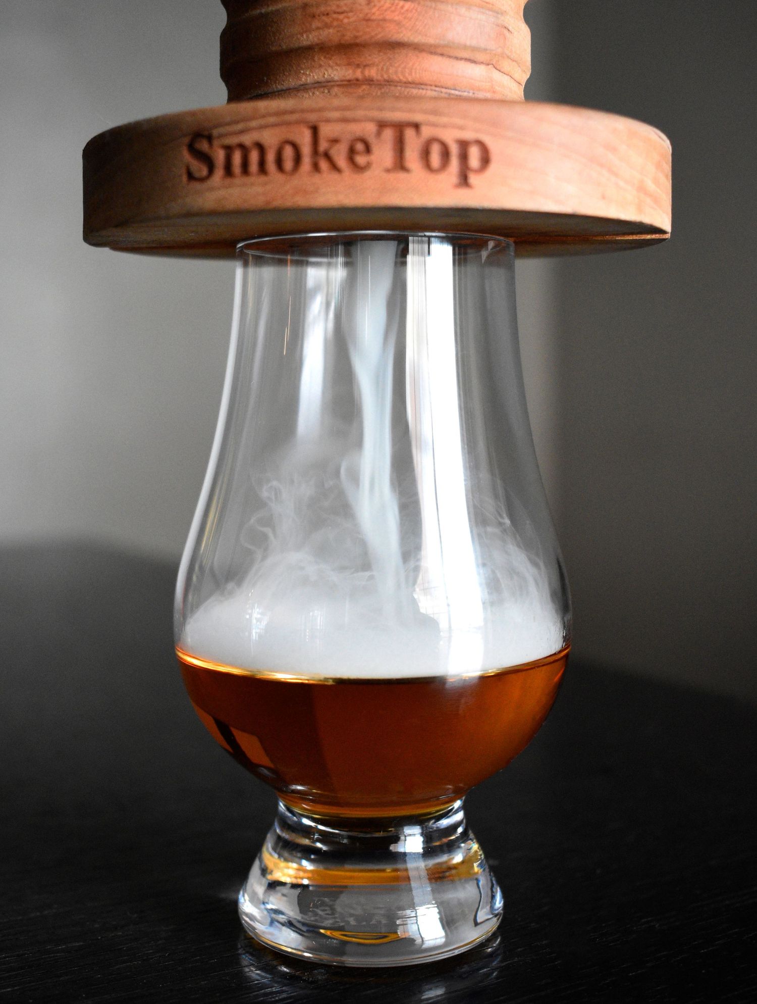 SmokeTop cocktail smoker infusing smoke into a Glencairn glass of bourbon whiskey.