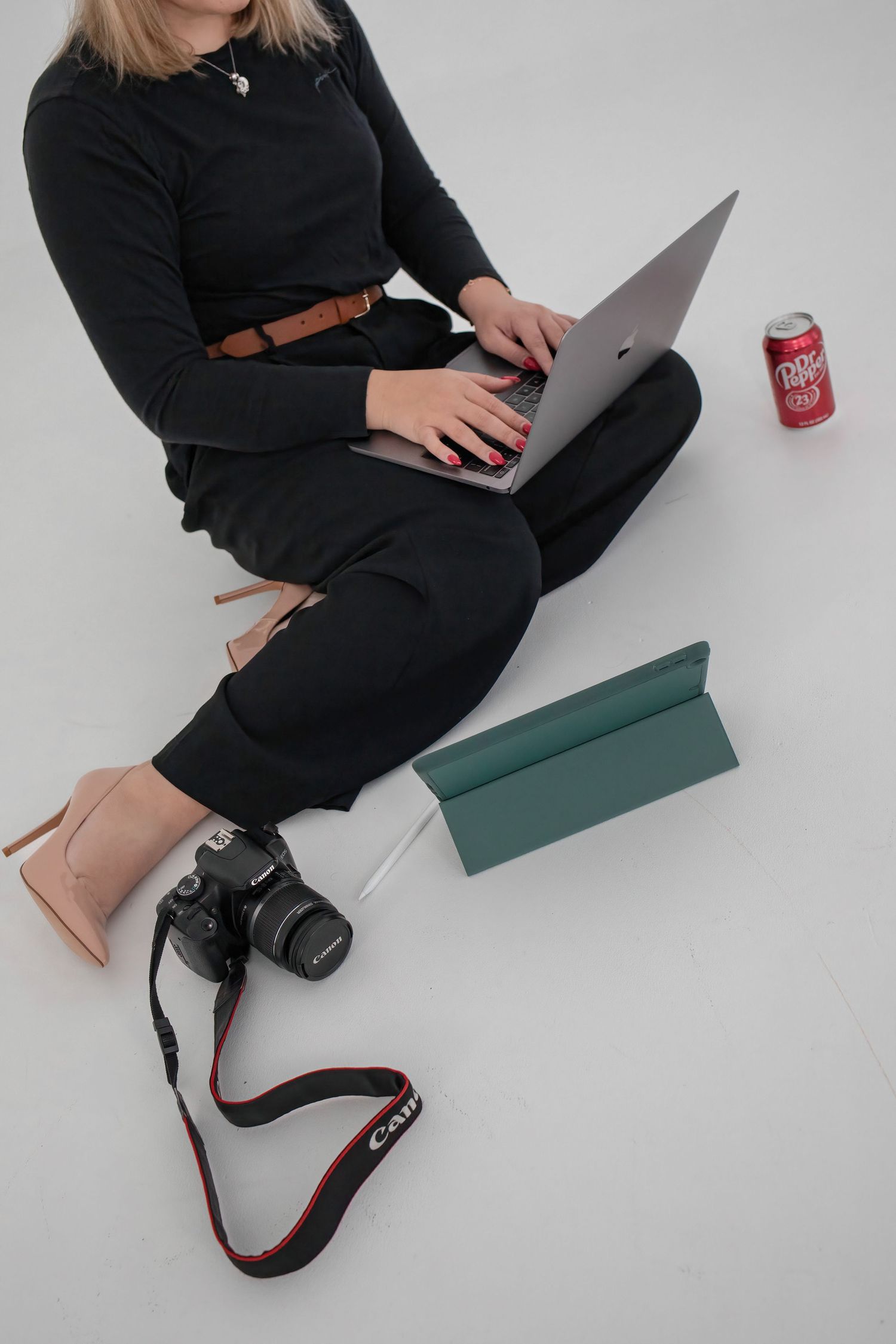 Image of Becka with computer, ipad, camera, and Dr Pepper