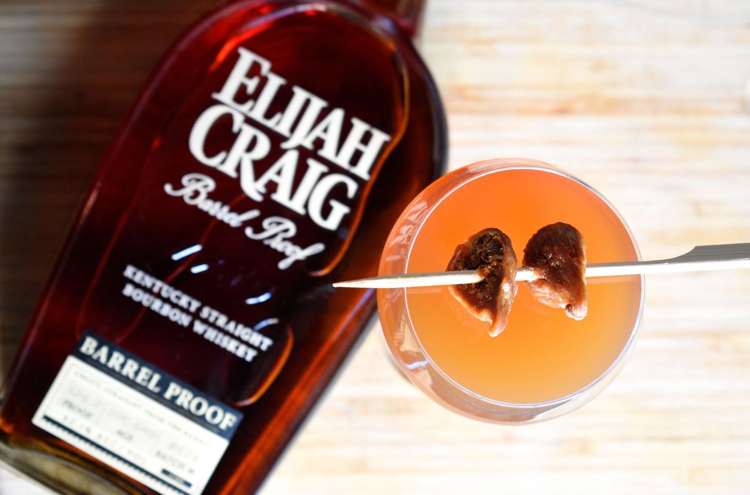 An Elijah Craig Barrel Proof bourbon cocktail garnished with a cherry in a coupe glass.
