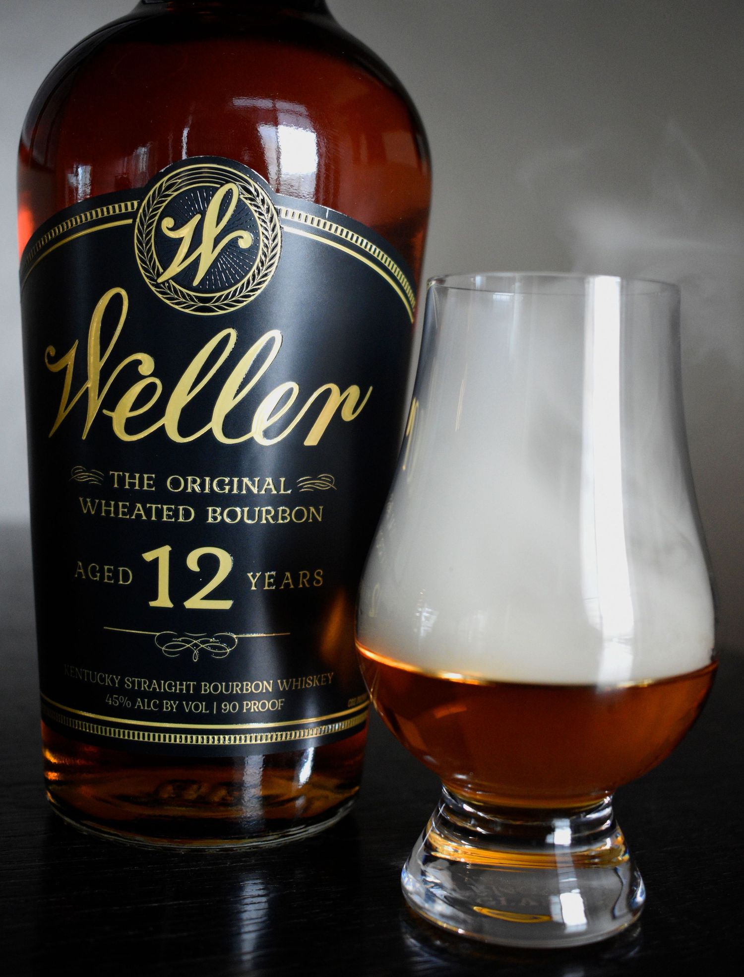 Weller 12 Year Original Wheated Bourbon bottle beside a Glencairn glass with amber whiskey.