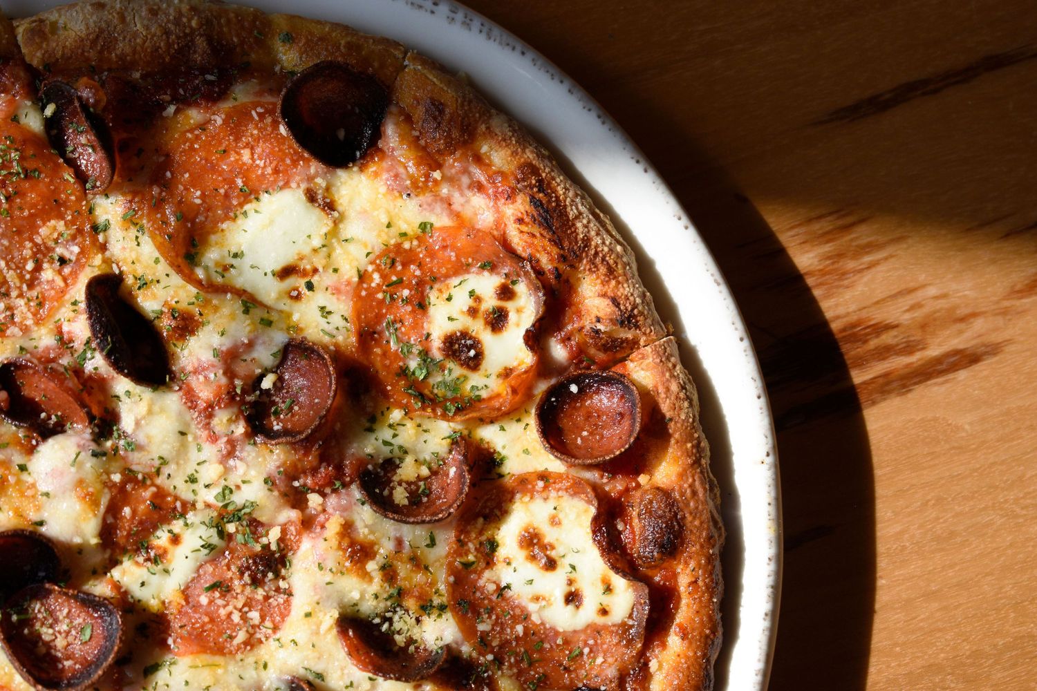 Close-up of a pepperoni pizza with melted mozzarella cheese in a round pan.
