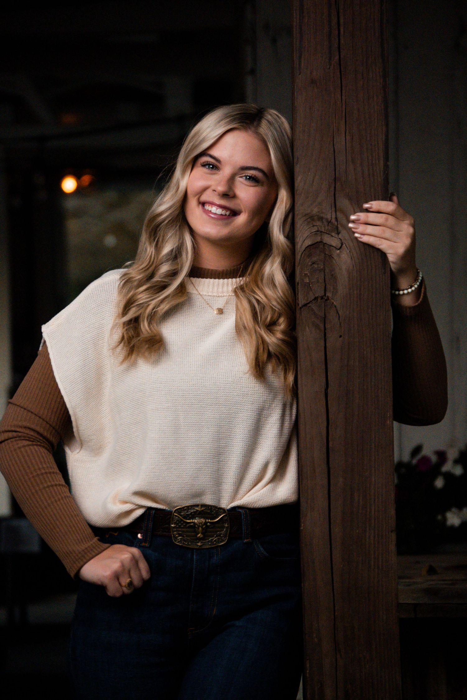 Fashion portrait featuring two-tone sweater and dark jeans in dramatic lighting.