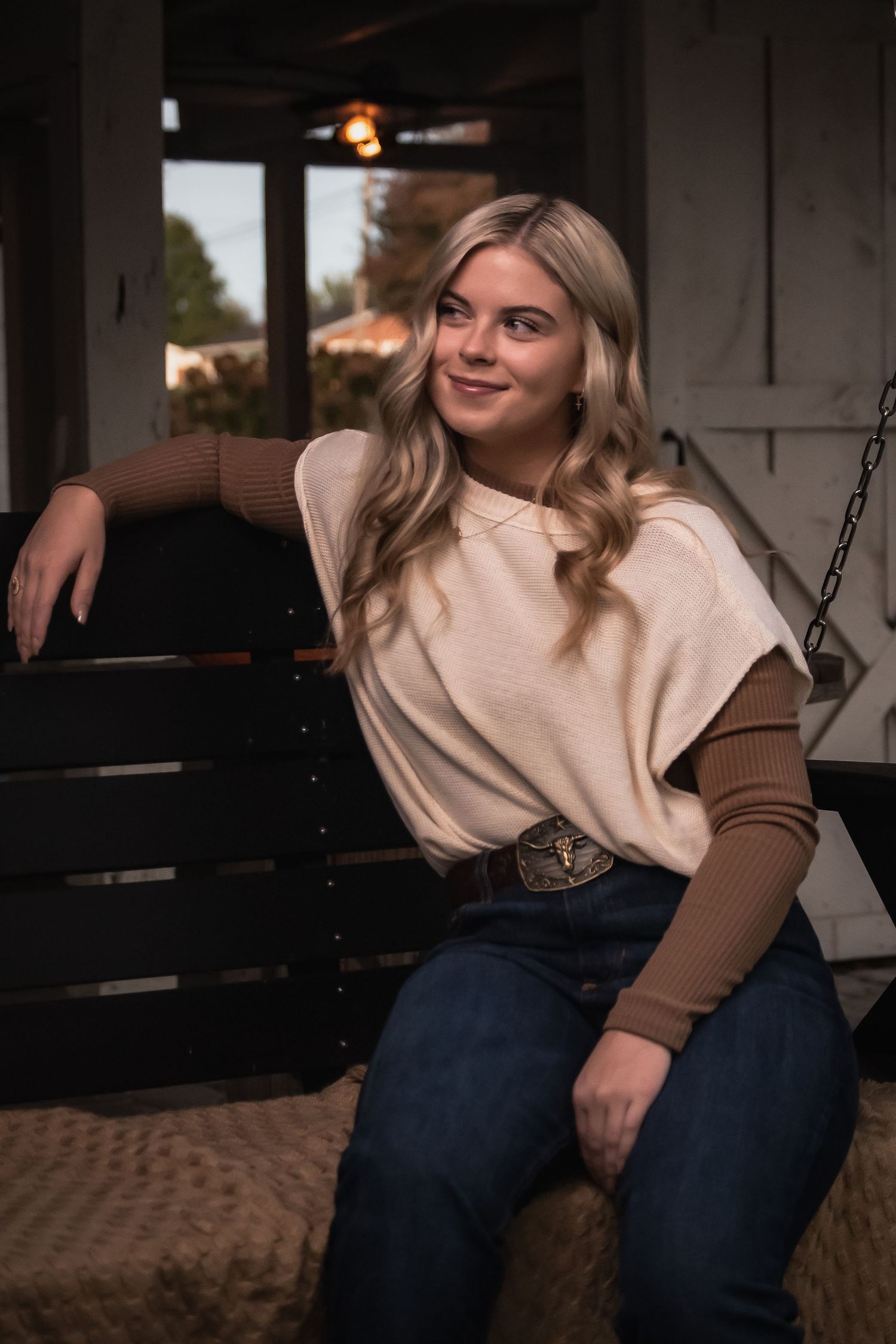 Cozy autumn style featuring cream top and dark denim in rustic indoor setting with natural light.