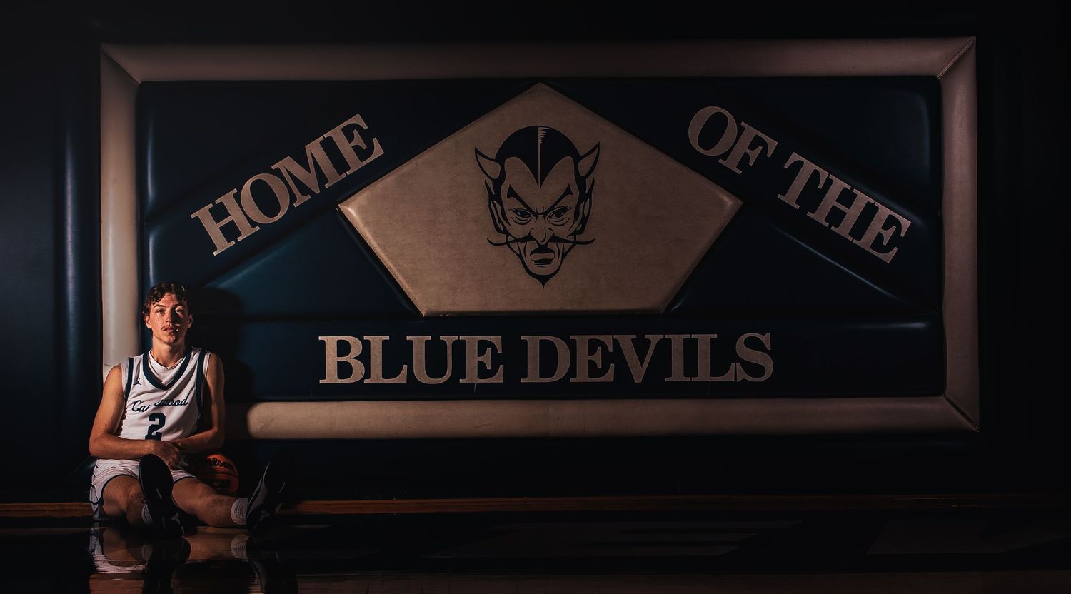 Blue Devils team sign displayed in dark setting with basketball imagery.