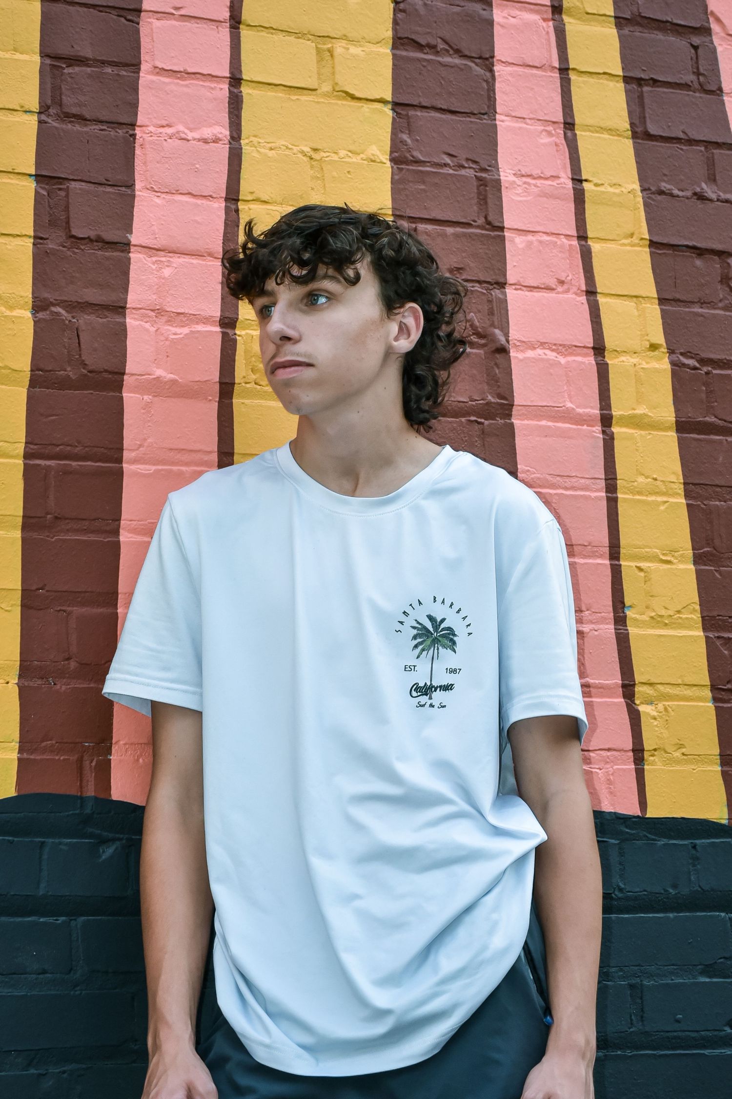 Casual portrait against striped painted wall in warm tones.
