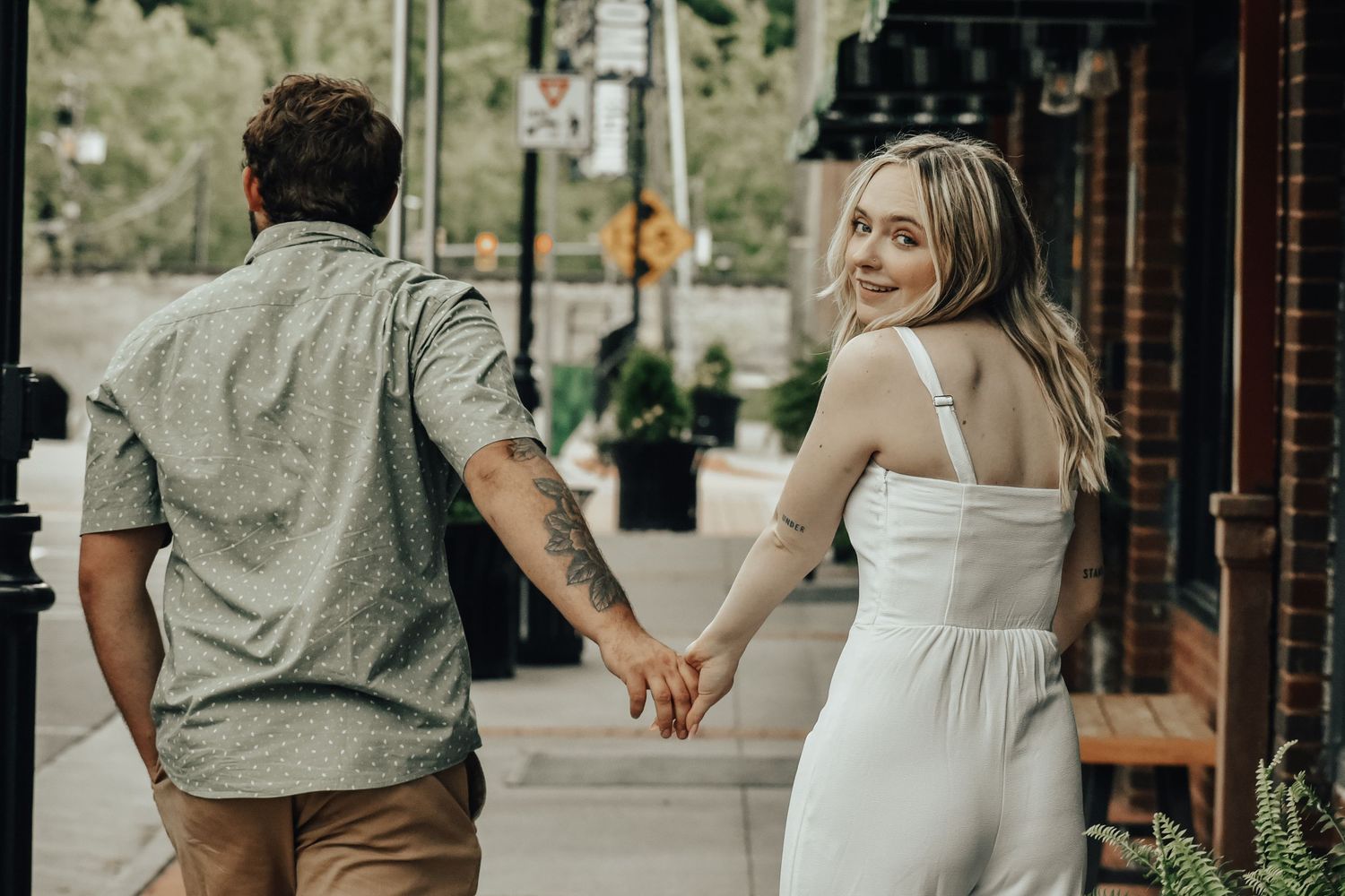A romantic outdoor photoshoot in front of the Western Front Hotel with a couple in casual attire.