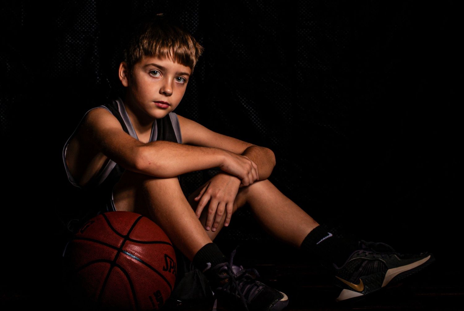 Dramatic black and white photo series showing athletic poses with basketball and dance movements against dark background.