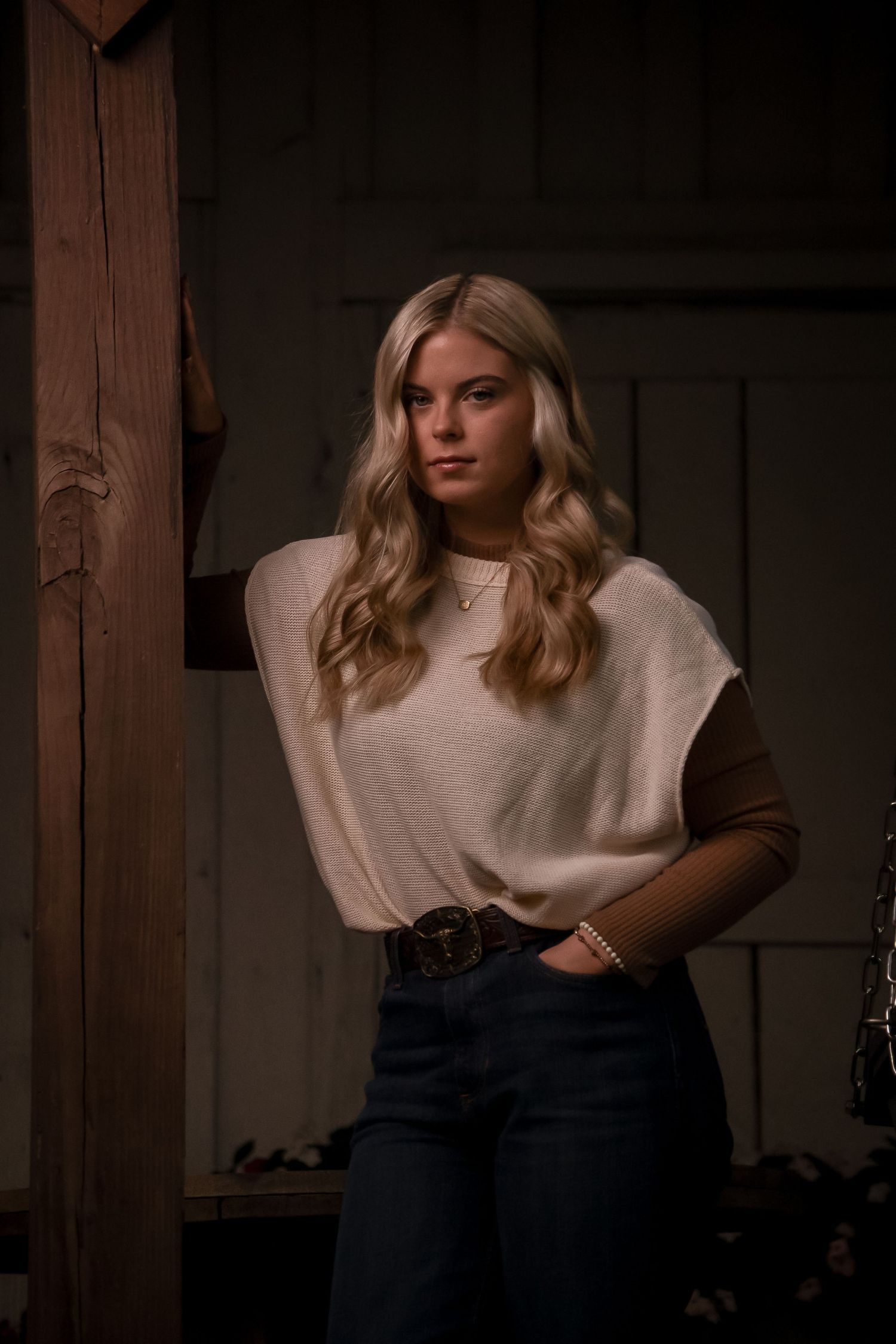 Fashion portrait series showing a woman in white top and dark jeans against a rustic wooden backdrop.