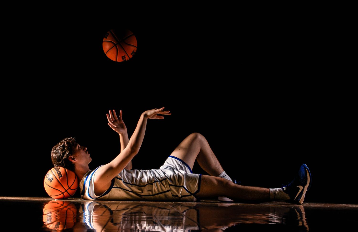 Basketball player demonstrates ball handling skills in horizontal action shot.