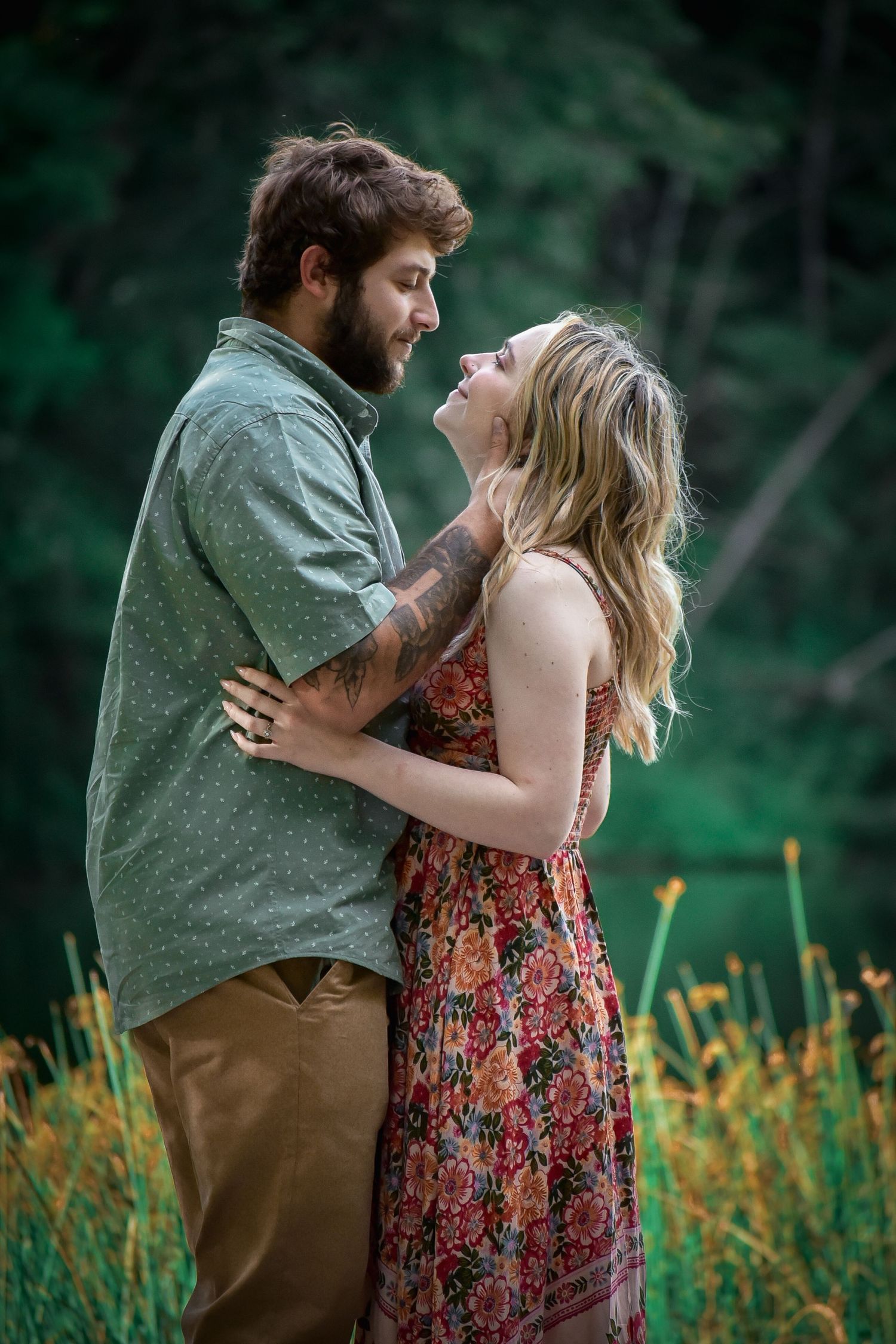 A romantic outdoor photoshoot with a couple embracing by a lake.