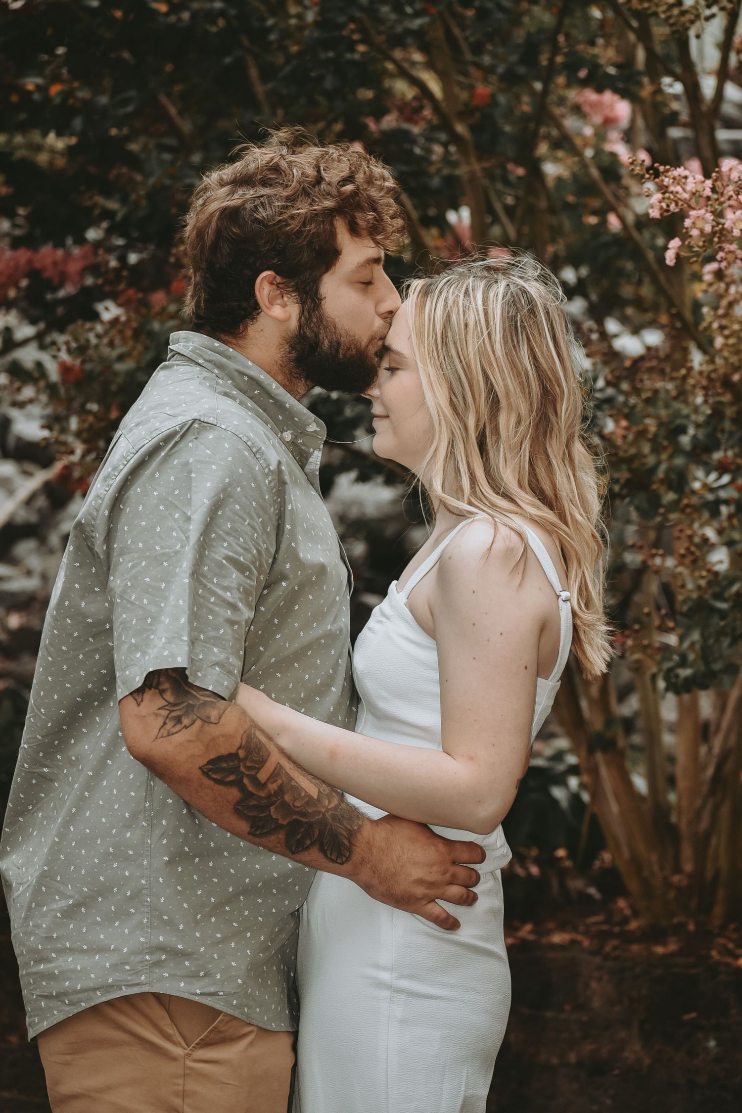 Intimate couple portrait session in front of blooming spring trees.
