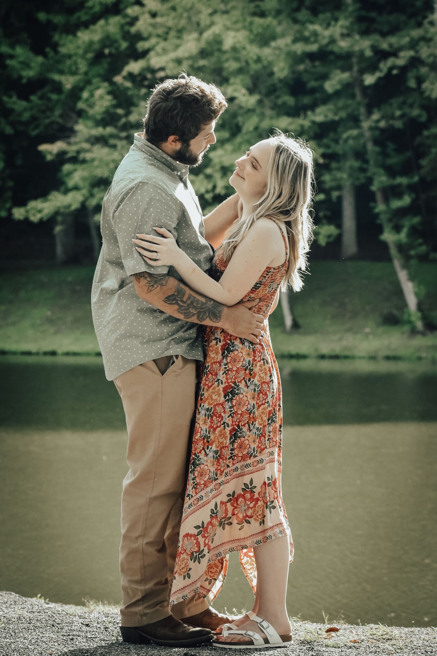 A romantic lakeside photoshoot with a couple embracing by the water.