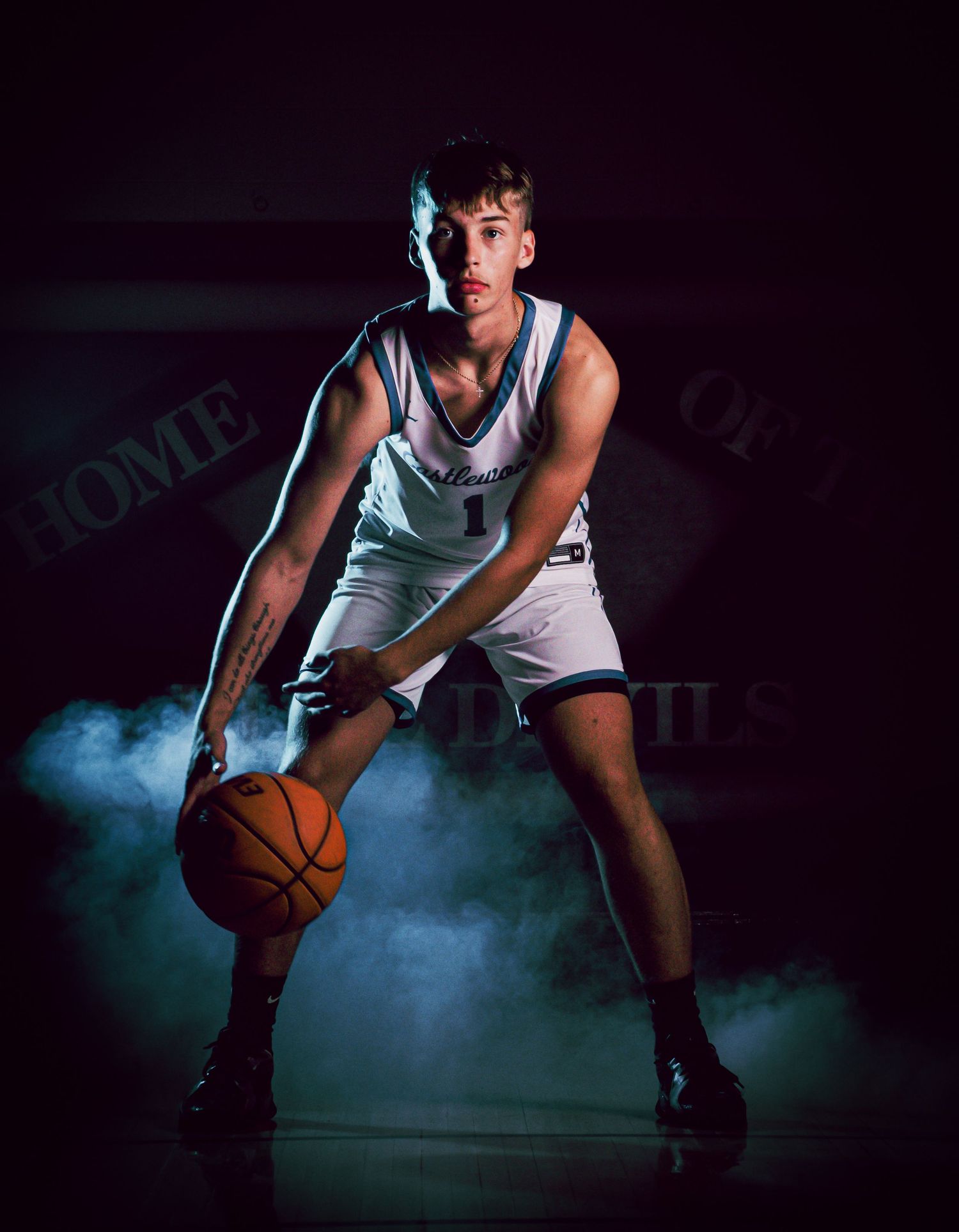 Basketball player in defensive stance with smoke effects and dramatic purple lighting.