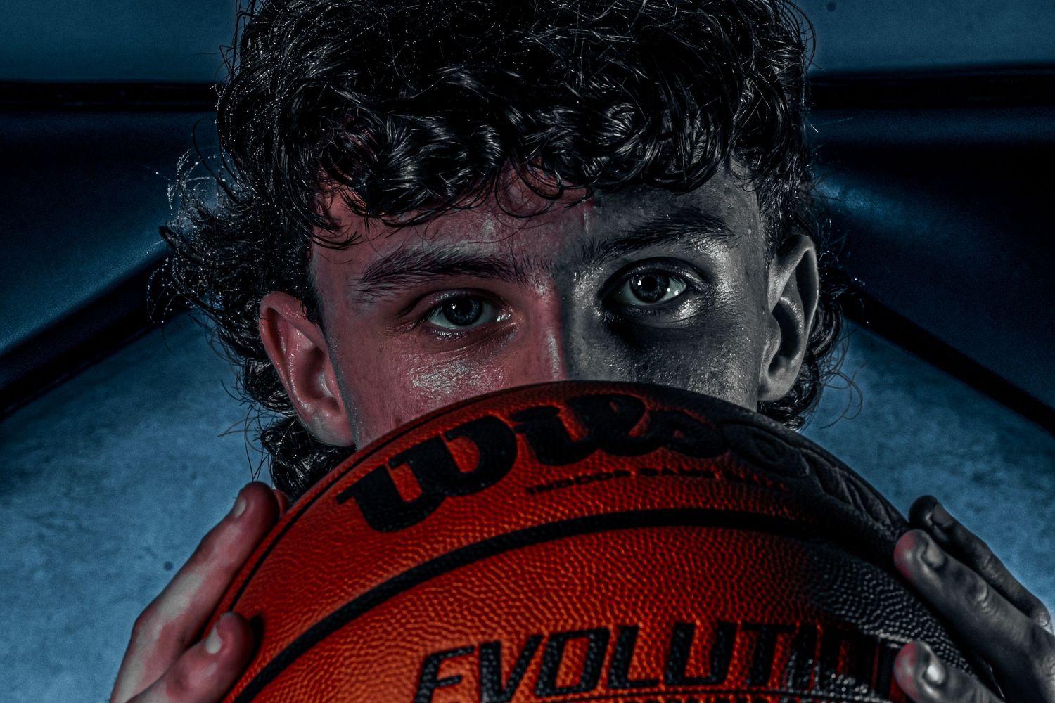 Artistic close-up of basketball with Evolution text visible in moody lighting.