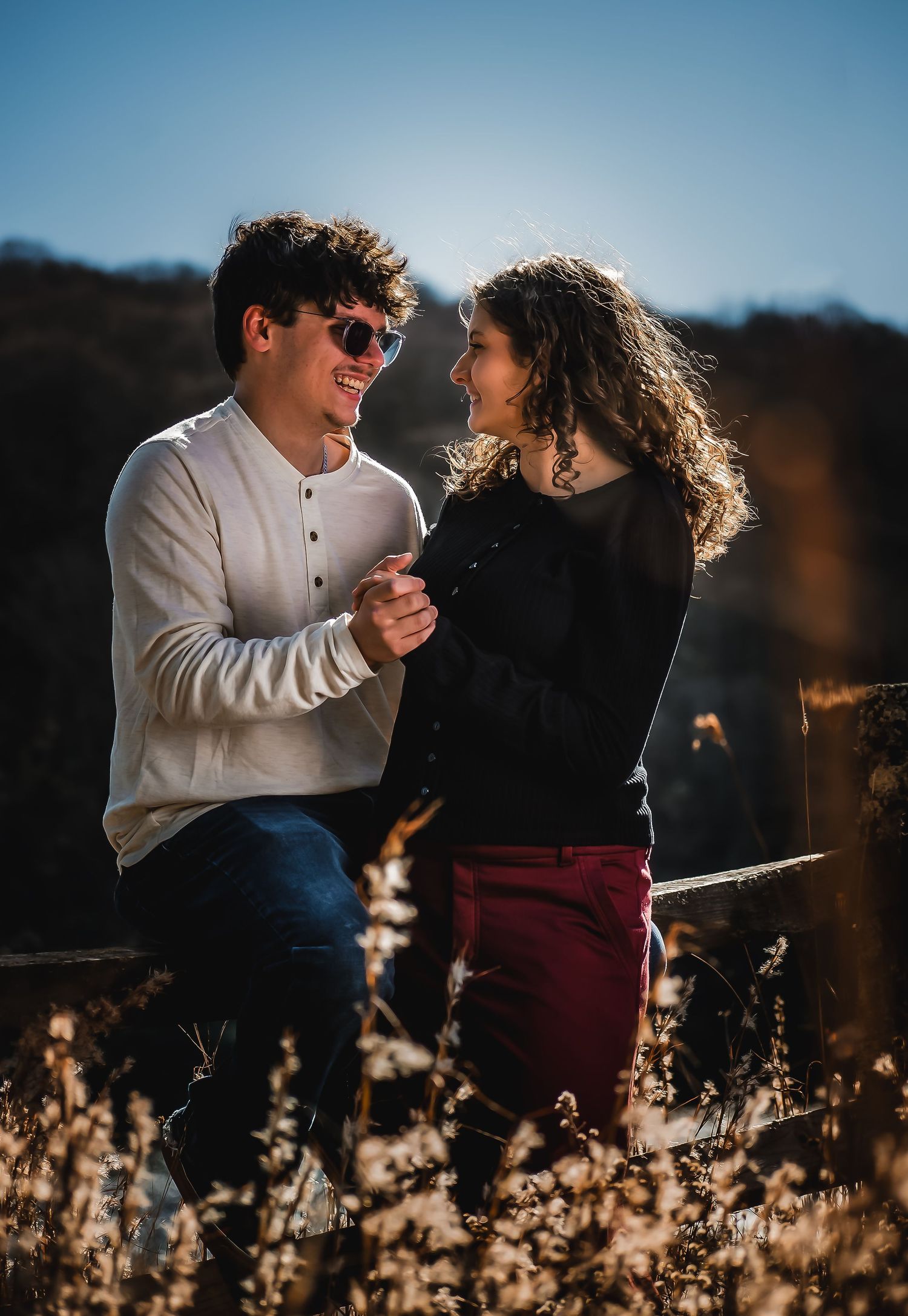 A couple laughs together while enjoying a sunny day outdoors.