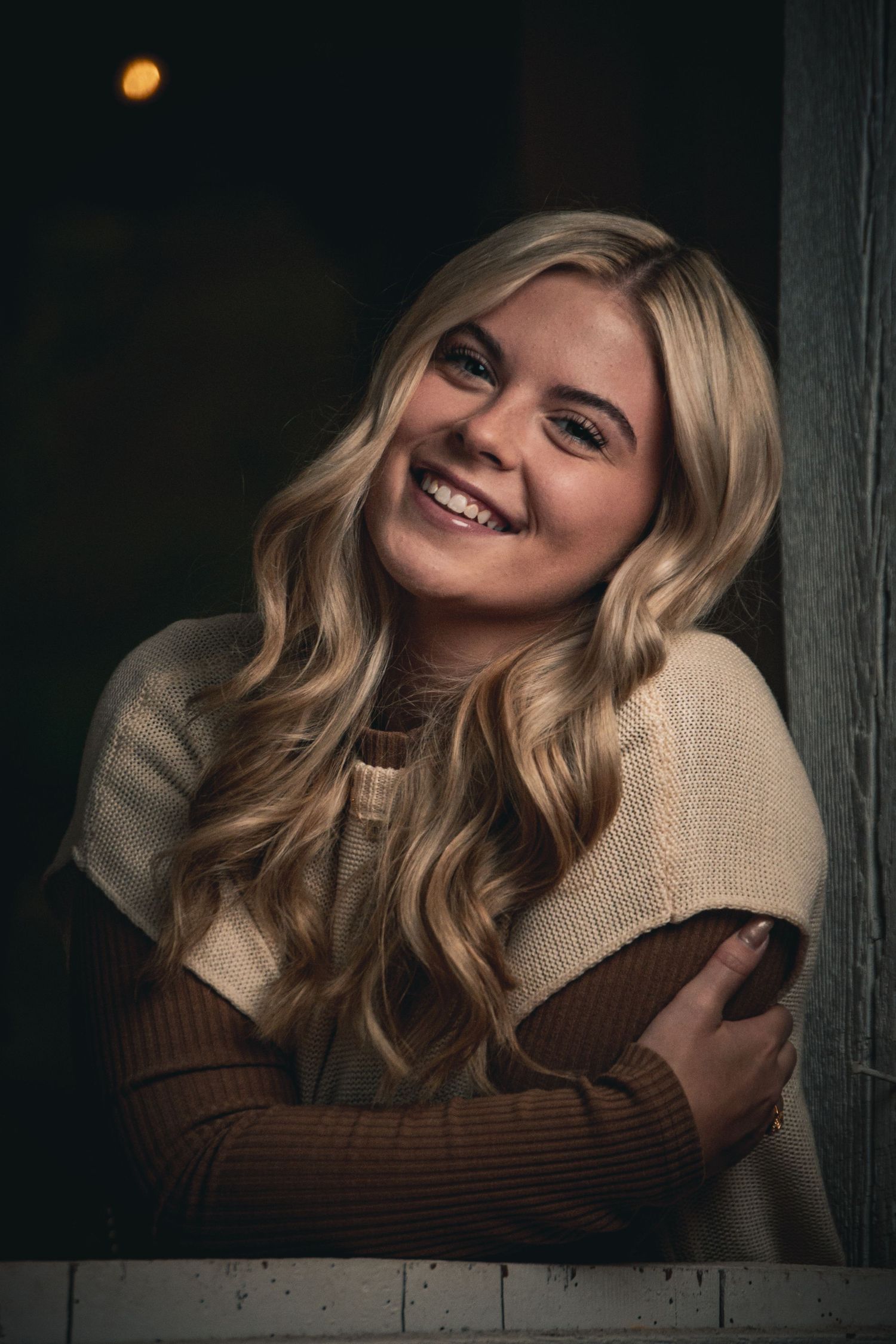 Cozy indoor photoshoot featuring warm autumn-toned clothing.
