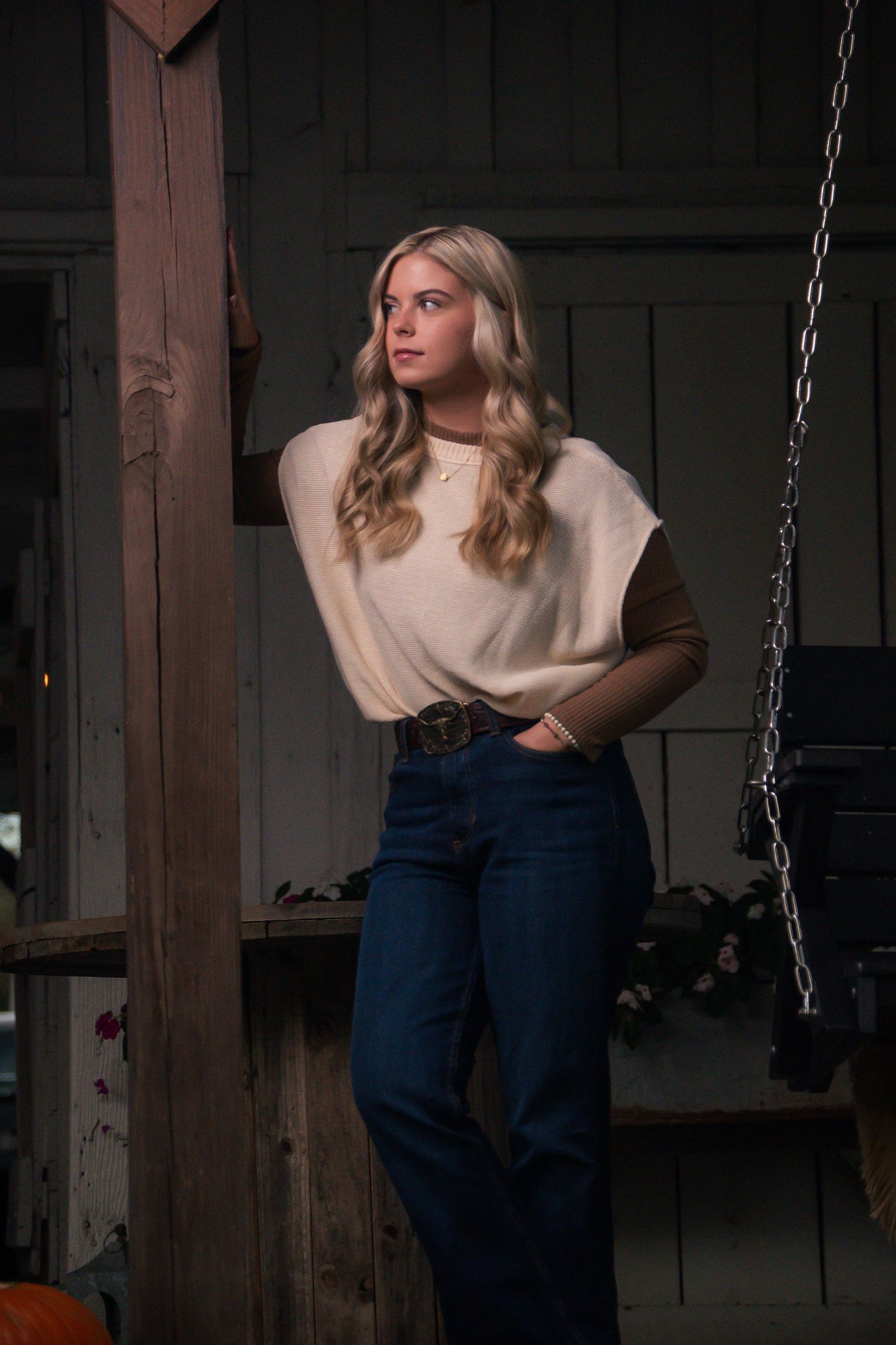 Fashion shoot against rustic backdrop with hanging chains and wooden beams.