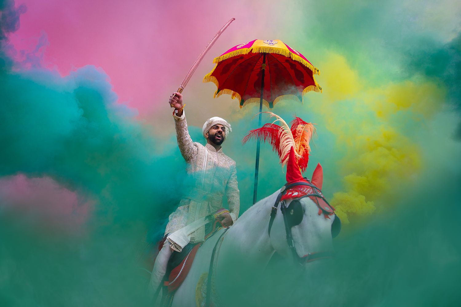 Dancers perform with umbrellas against a backdrop of pink and turquoise smoke in an artistic outdoor shoot.