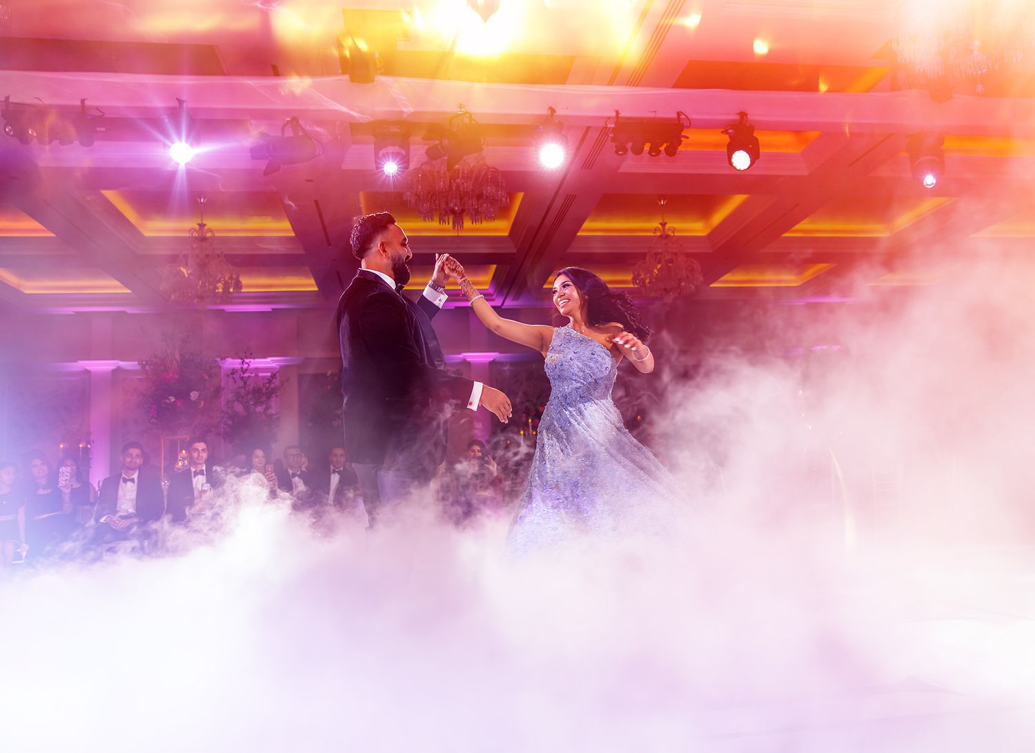 Dramatic sunset lighting creates an atmospheric scene with fog effects at an indoor event.