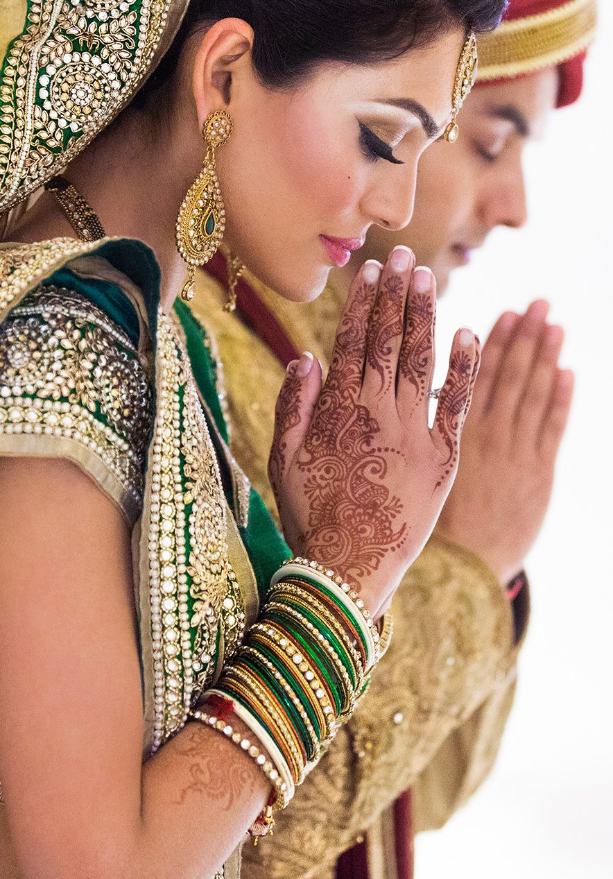 Traditional Indian bridal details showing intricate henna designs and green and gold bangles.