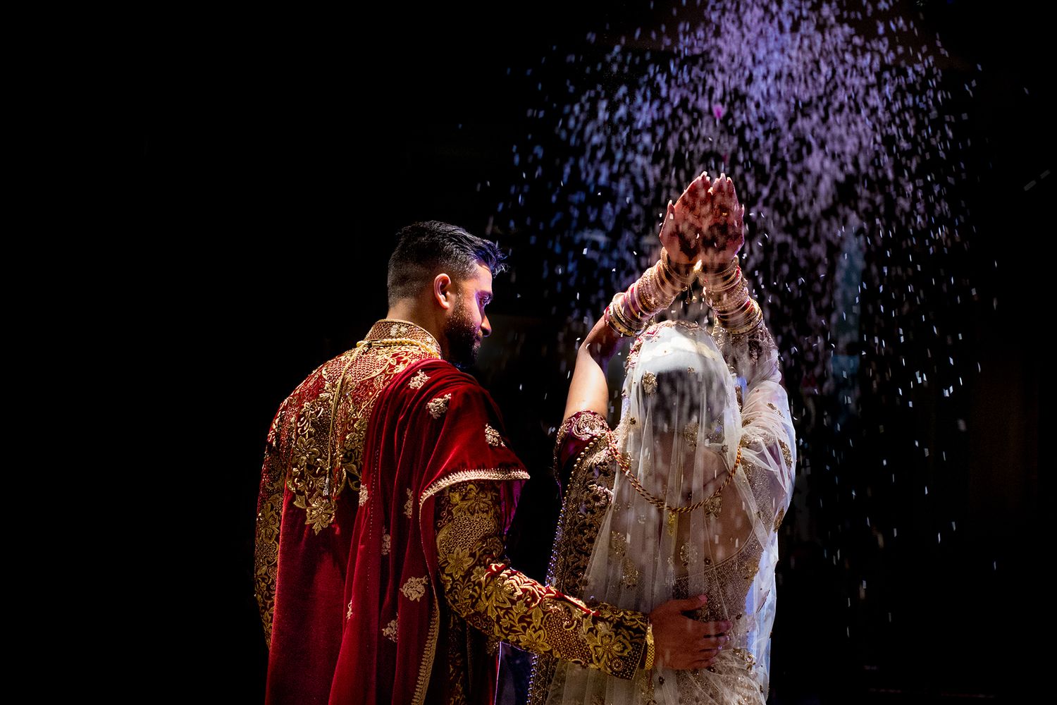 Glittering confetti falls during a celebratory moment at an indoor event.
