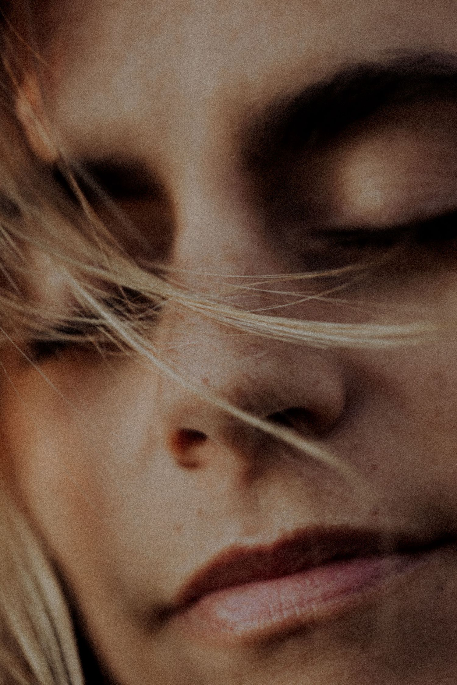 Close-up artistic portrait showing soft focus features in sepia tones.