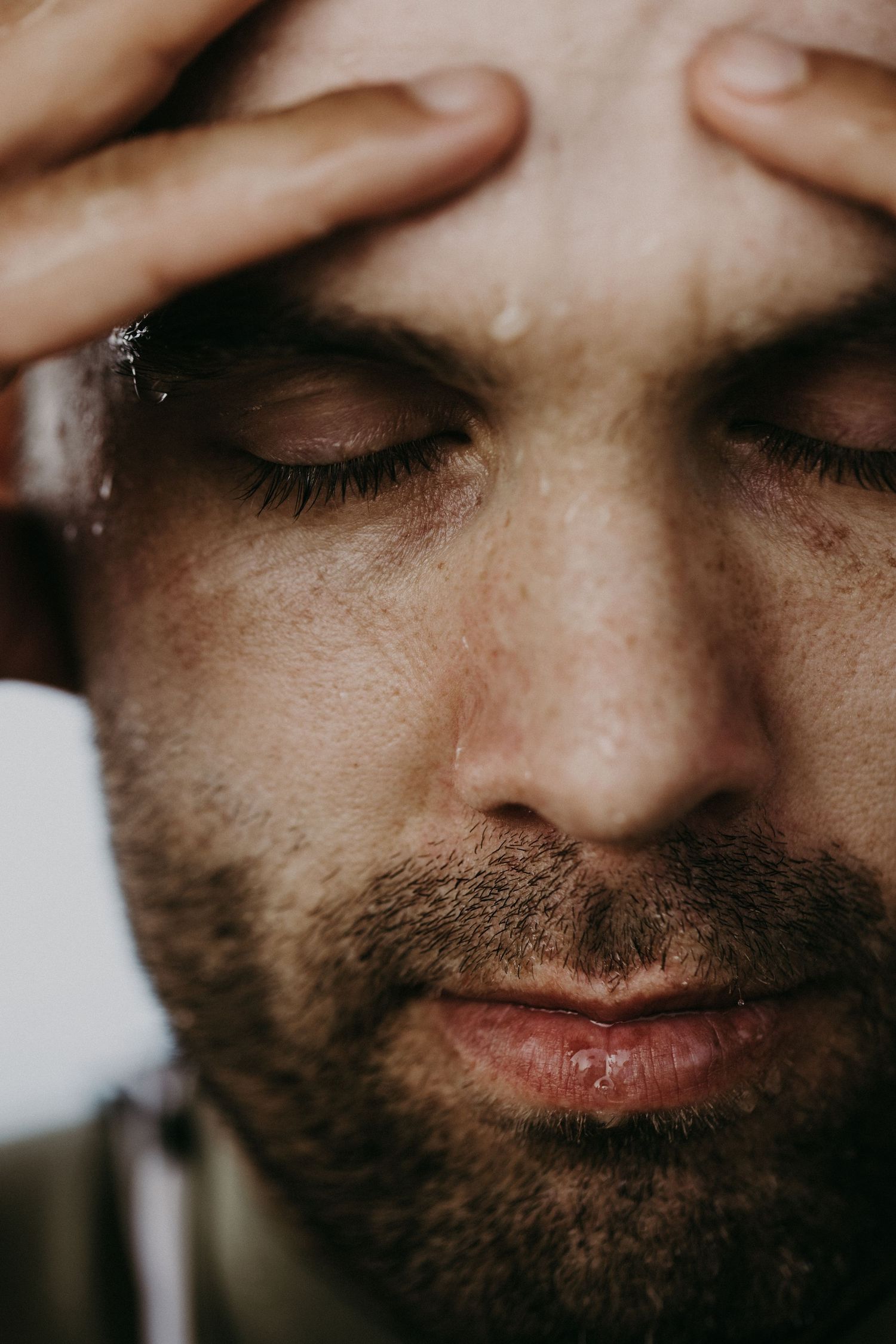 Close-up macro shots of facial features and beard stubble in dramatic lighting.