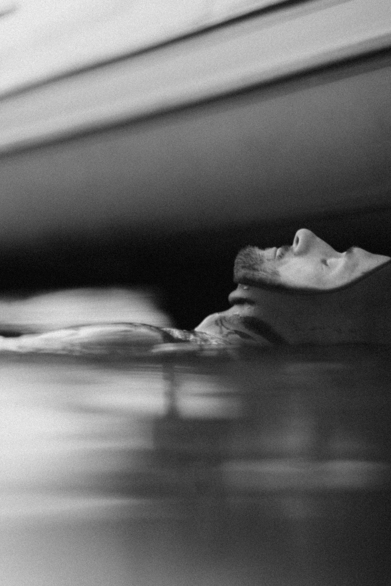 Minimalist black and white photo sequence showing a profile view in shallow water.