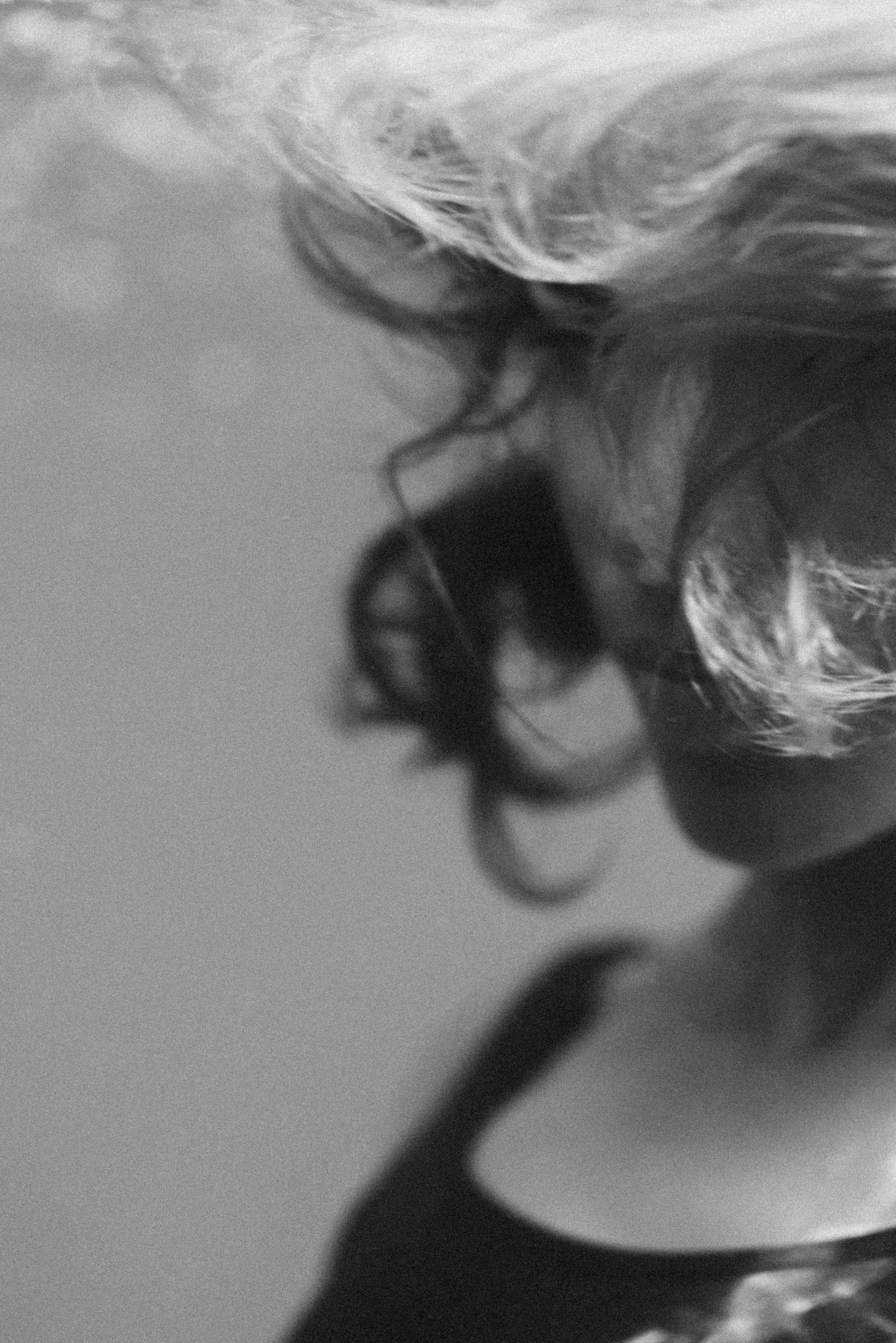Grayscale sequence showing windswept hair movement against light background.