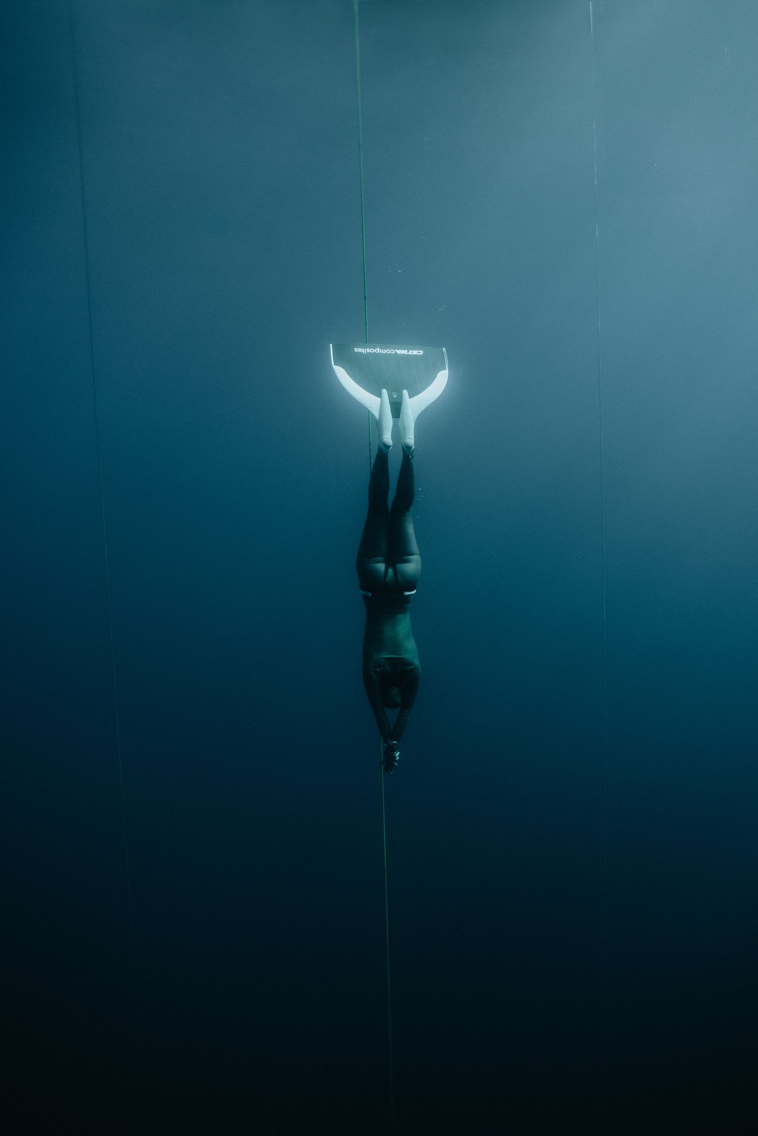 Underwater silhouette sequence showing a figure descending in deep blue waters.