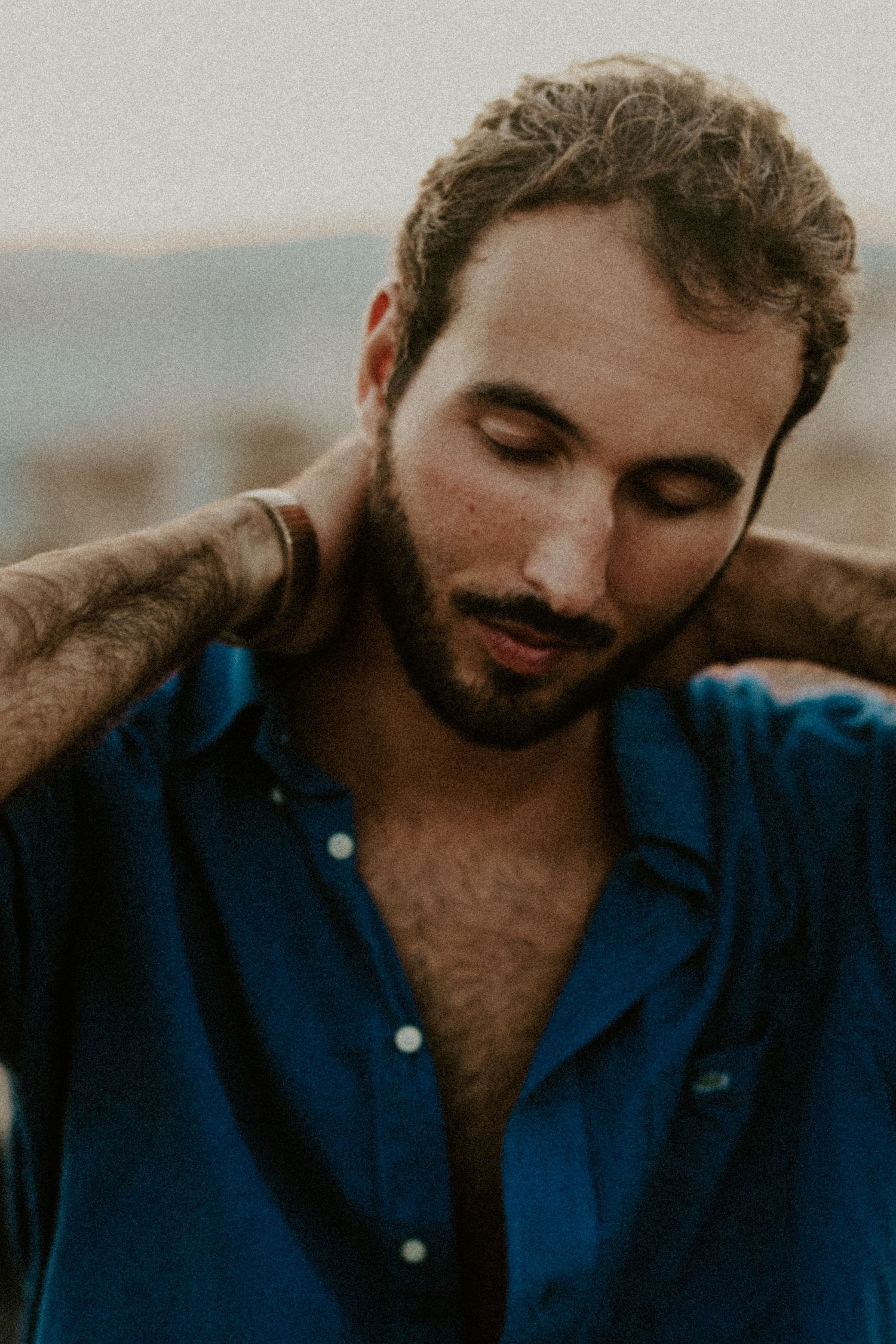 A person in a navy blue shirt shown in a series of cropped portrait shots with warm lighting.