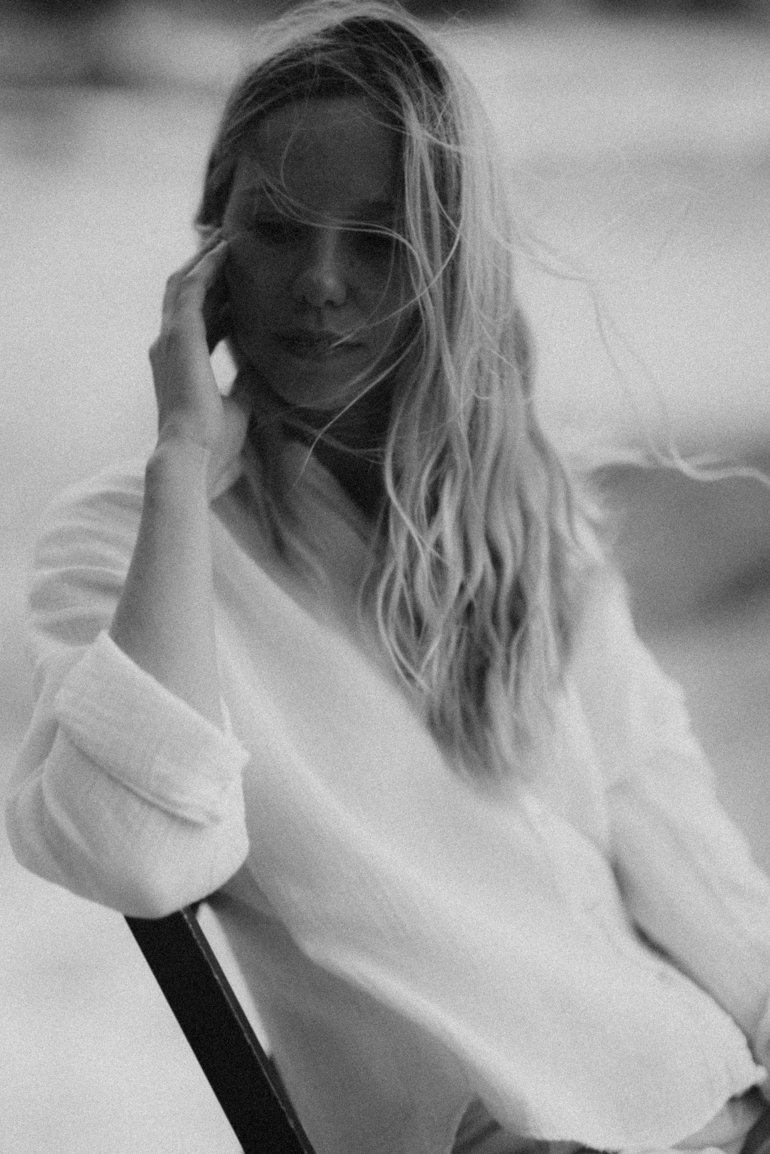 Artistic black and white portraits showing movement in white sweater.