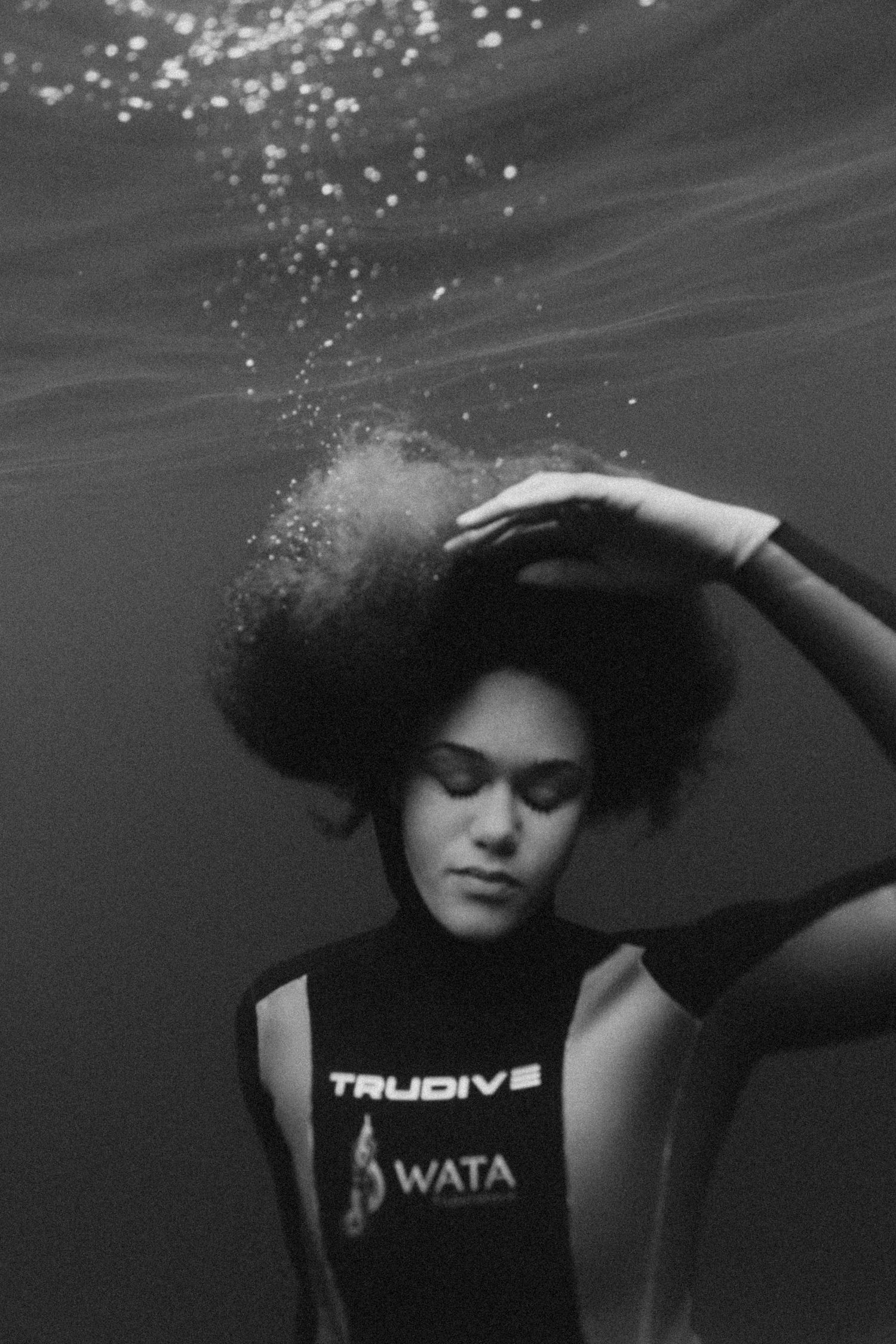 Black and white underwater fashion series showing athletic wear and natural hair movement.