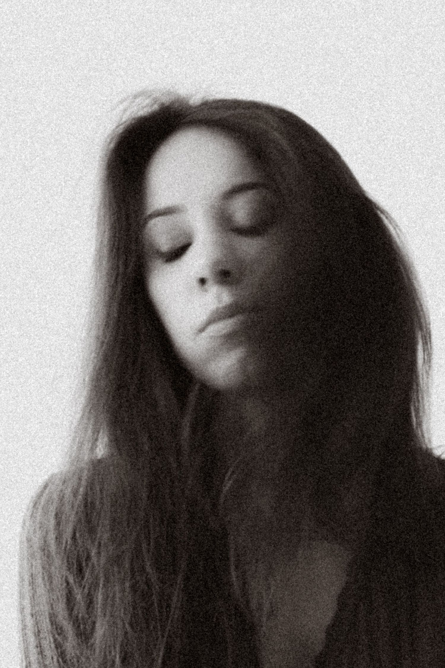Moody black and white close-up portraits showing a woman with closed eyes and flowing dark hair.