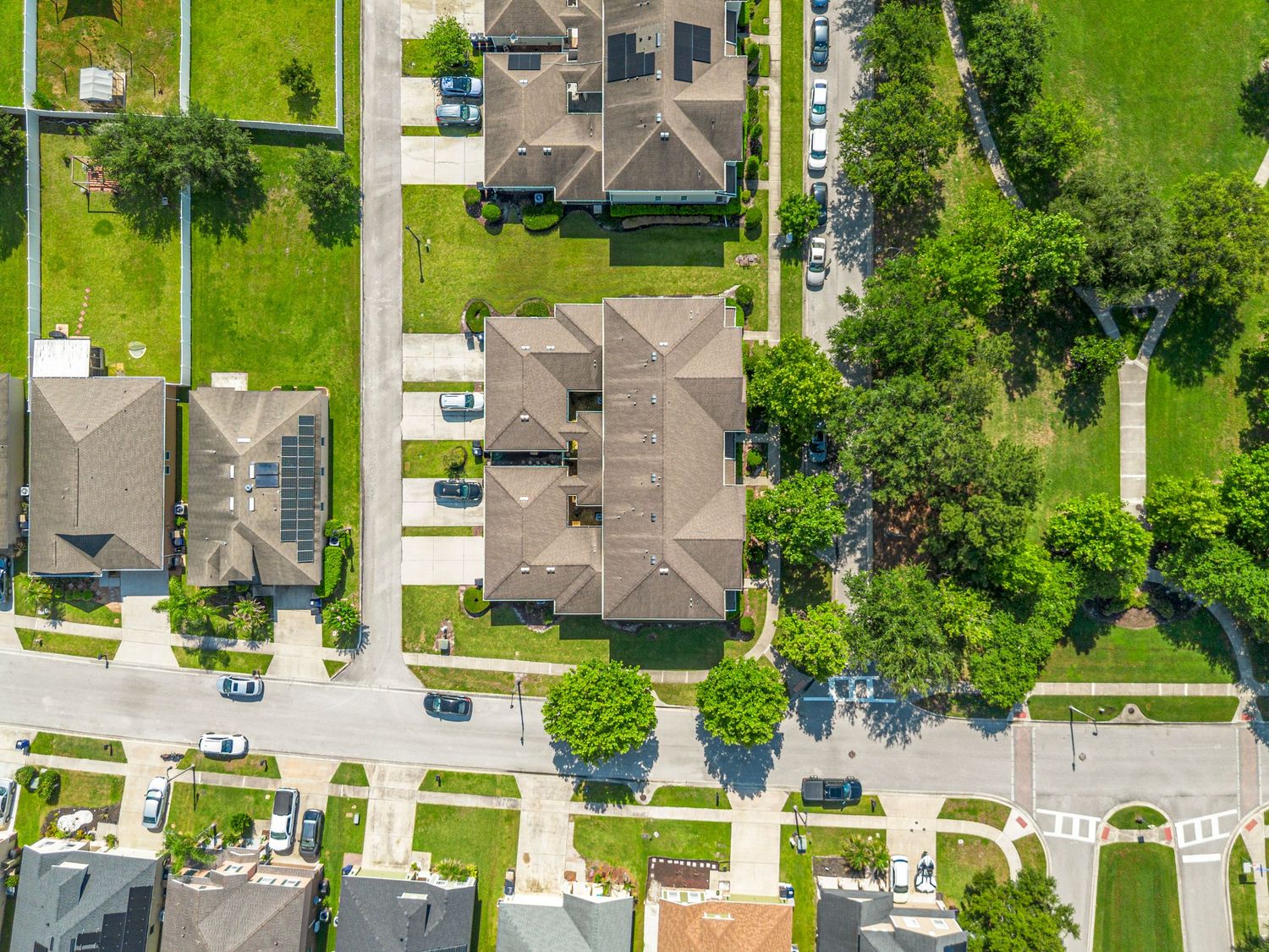 Top-down drone photo of a Central Florida residential street, homes, sidewalks, and landscaped neighborhood lots.